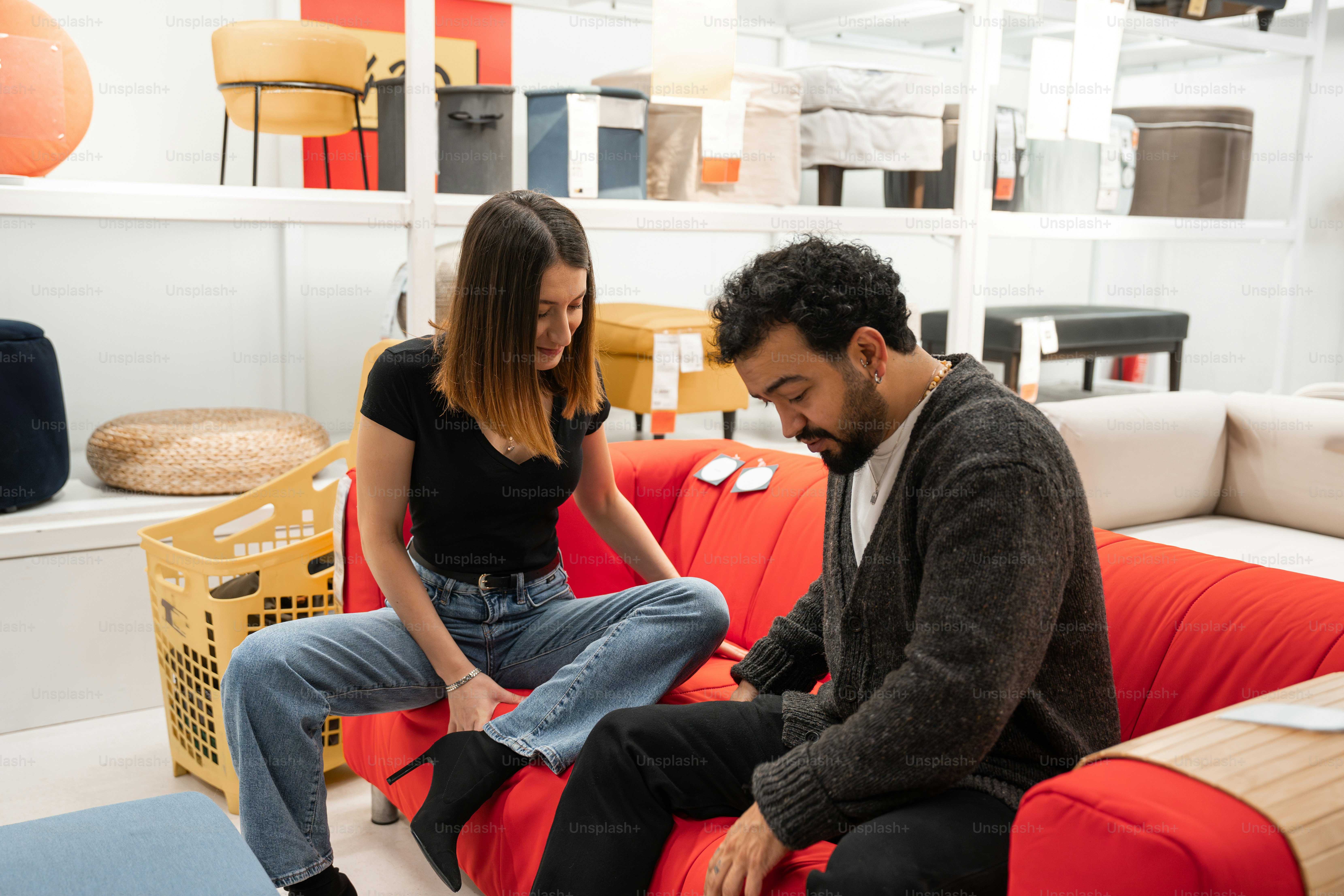 A man and a woman sitting on a red couch