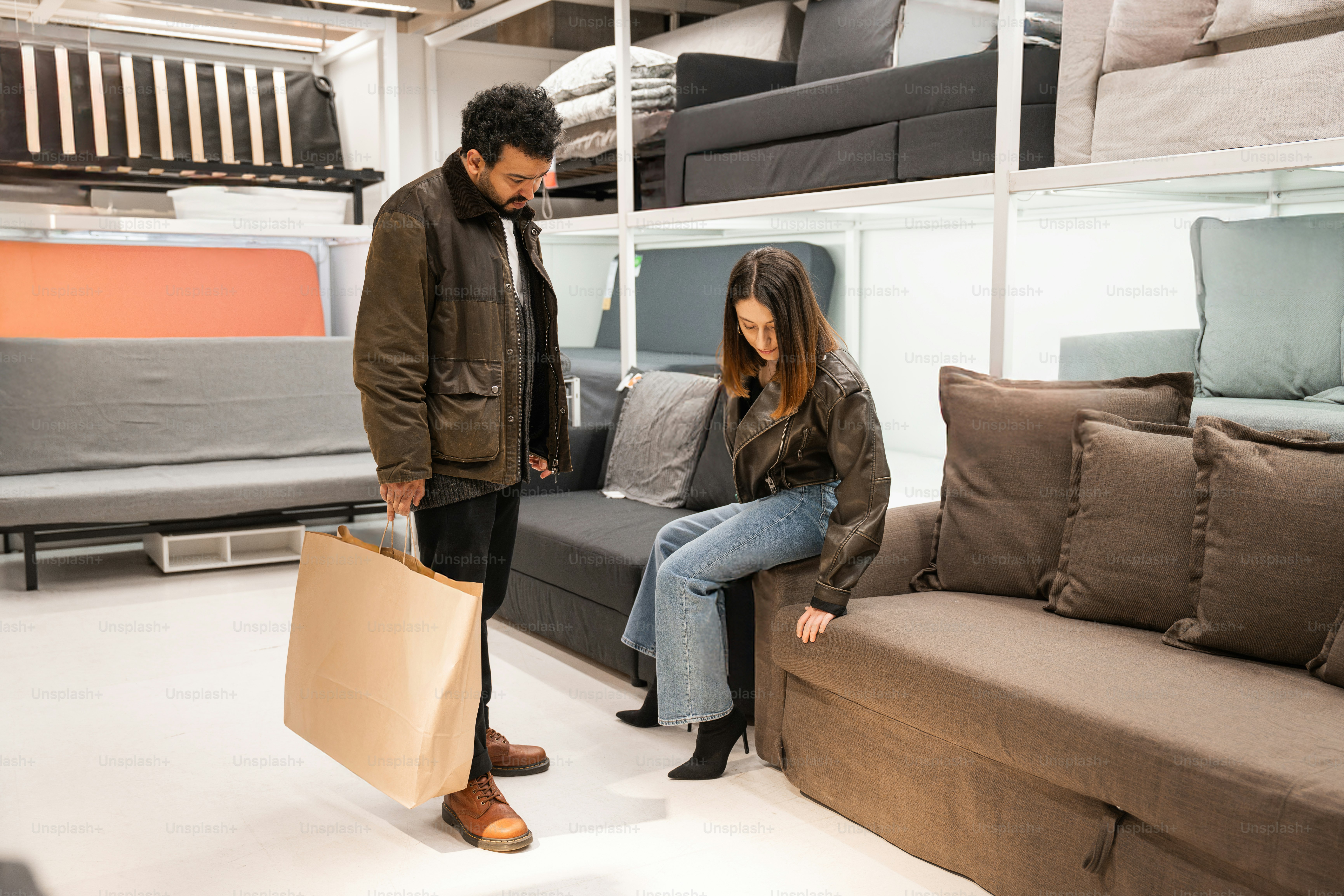A man and a woman are looking at a couch