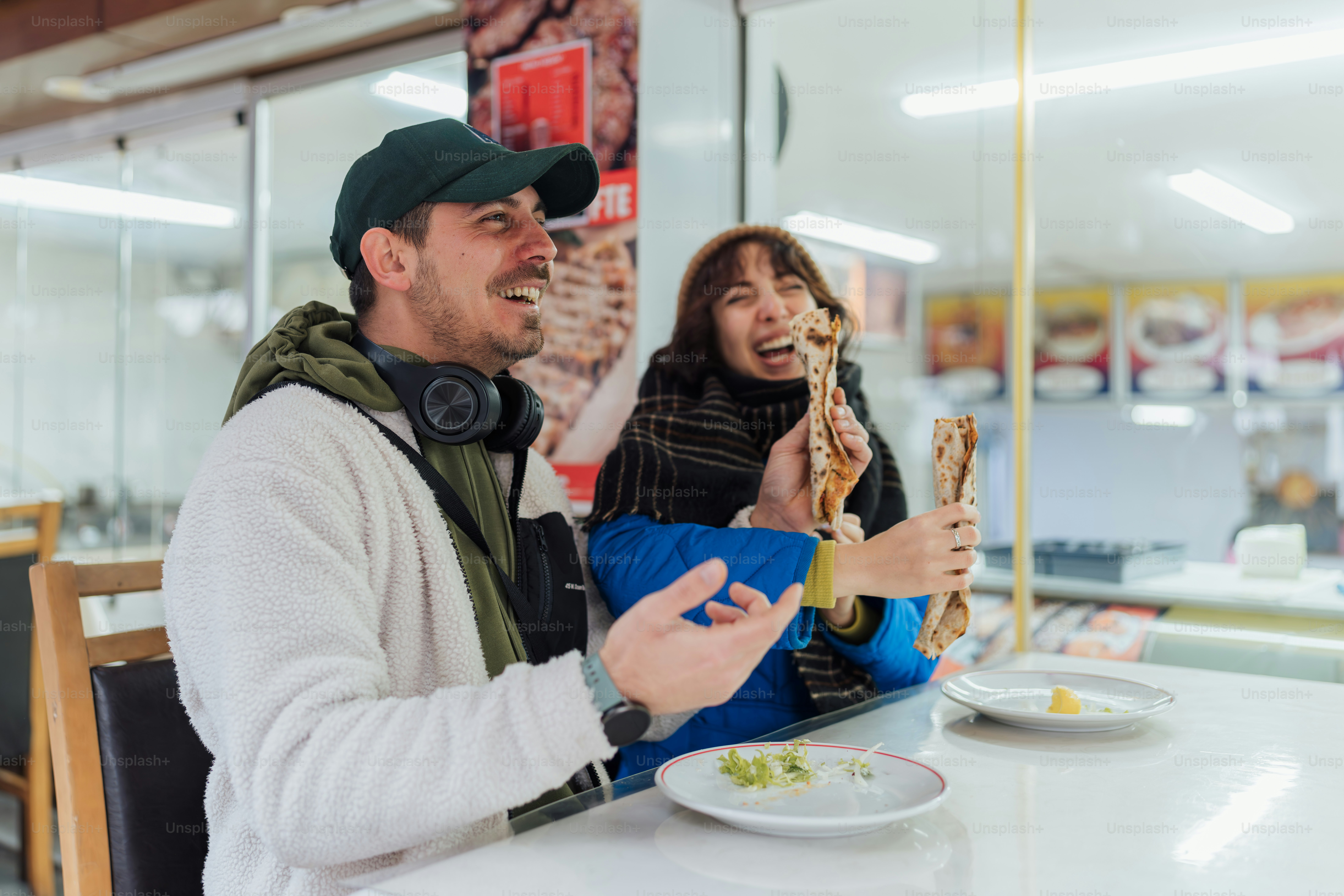 A man and woman sitting at a table eating pizza