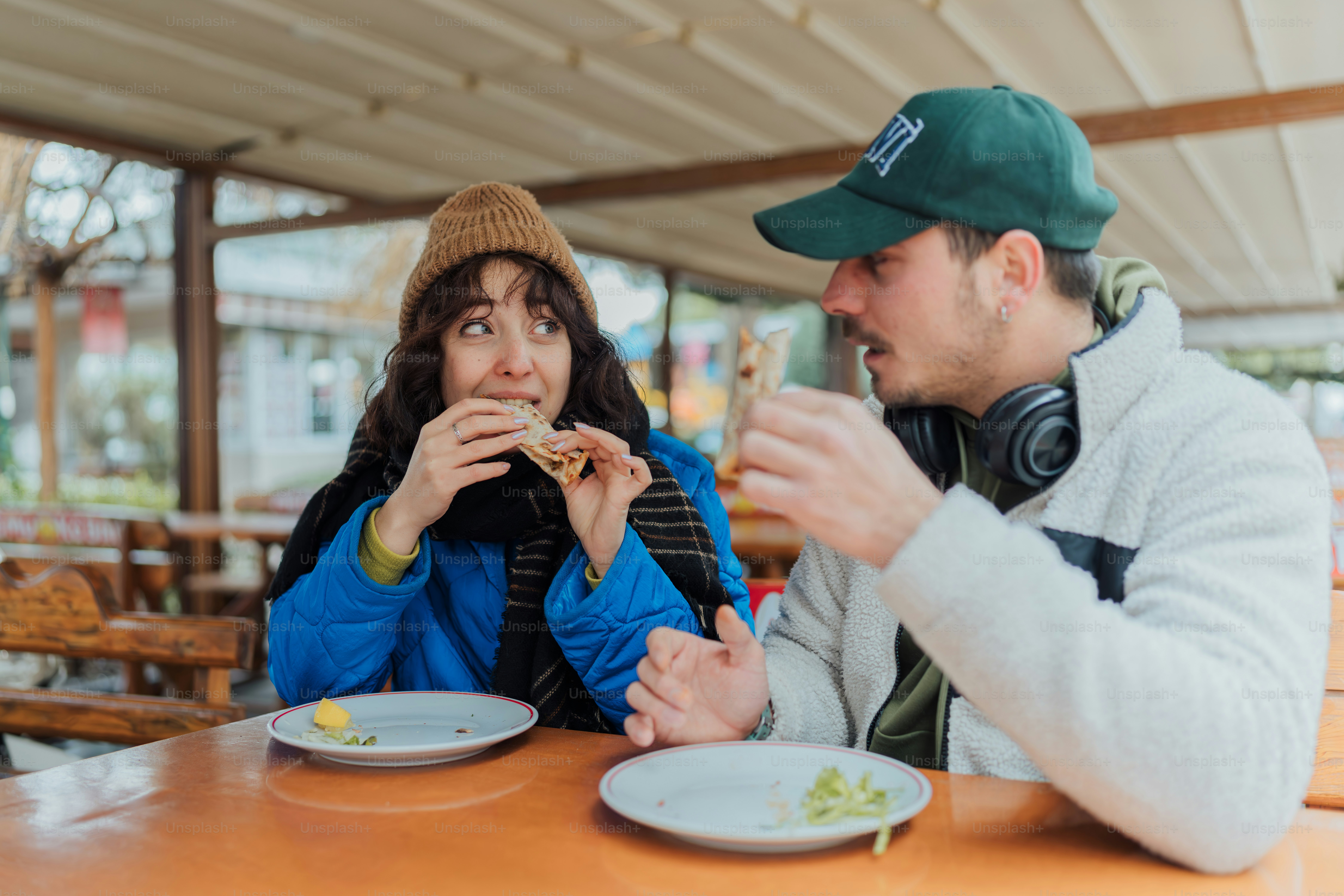 A man and woman sitting at a table eating food