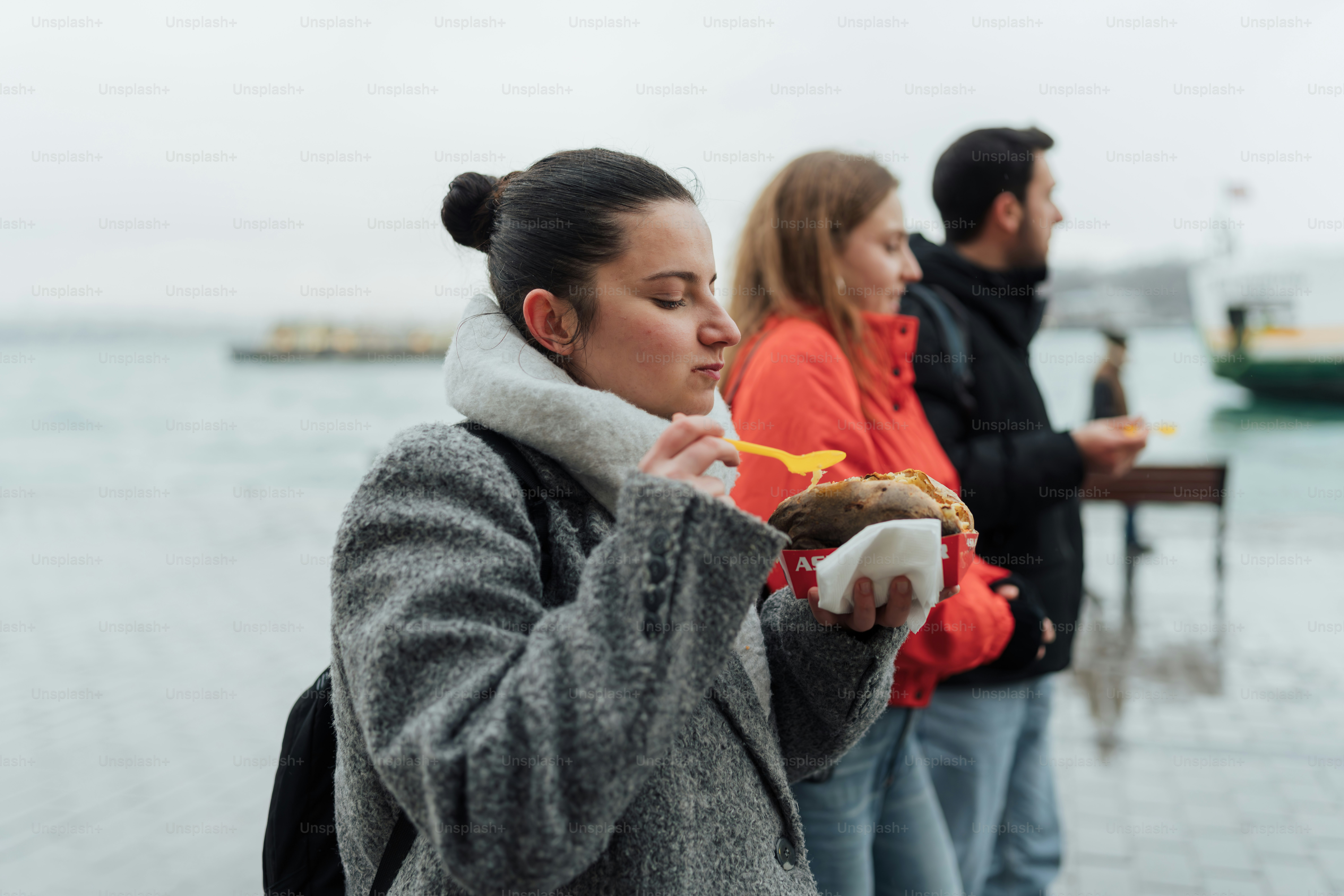 A group of people standing next to a body of water