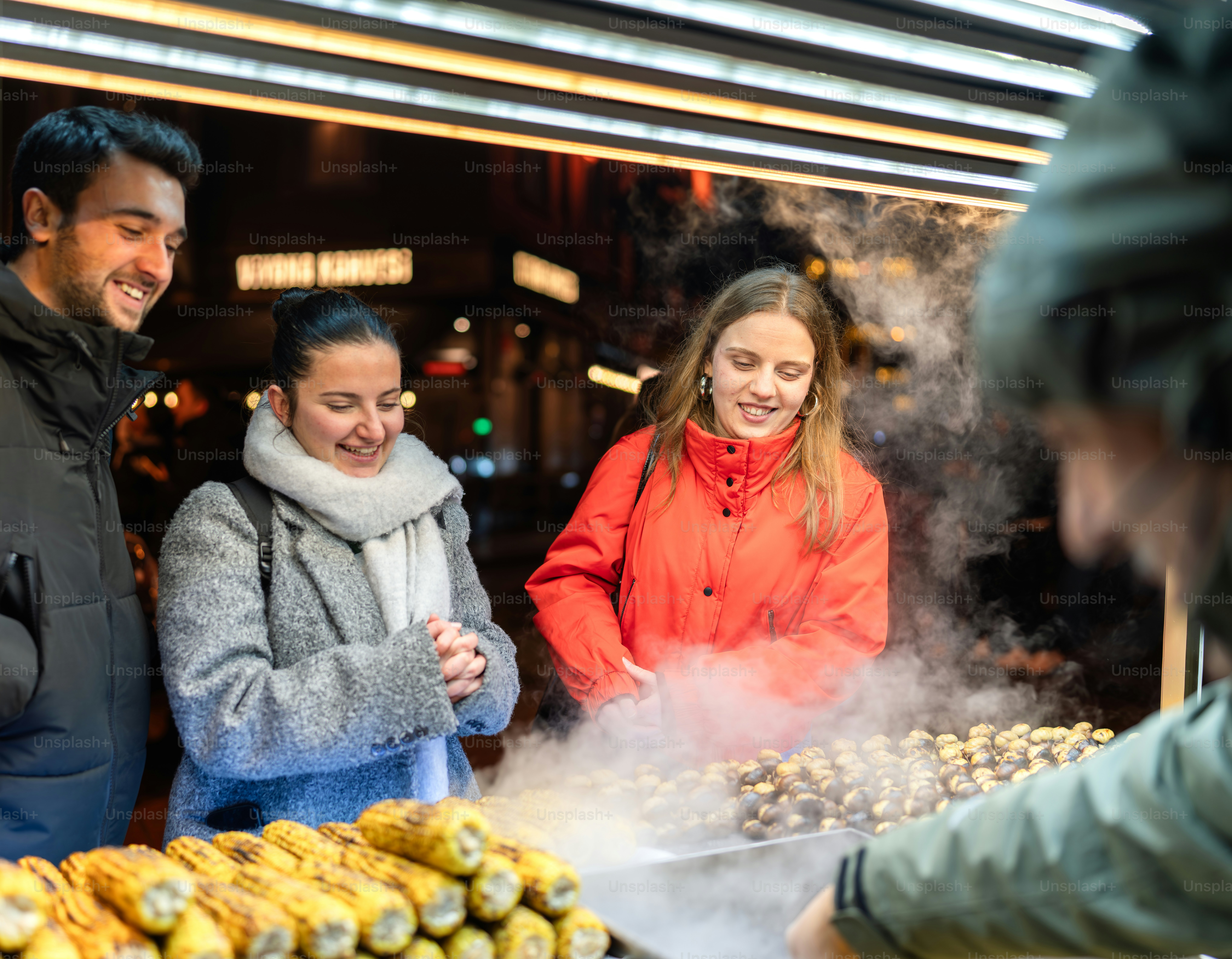 A group of people standing around a food stand