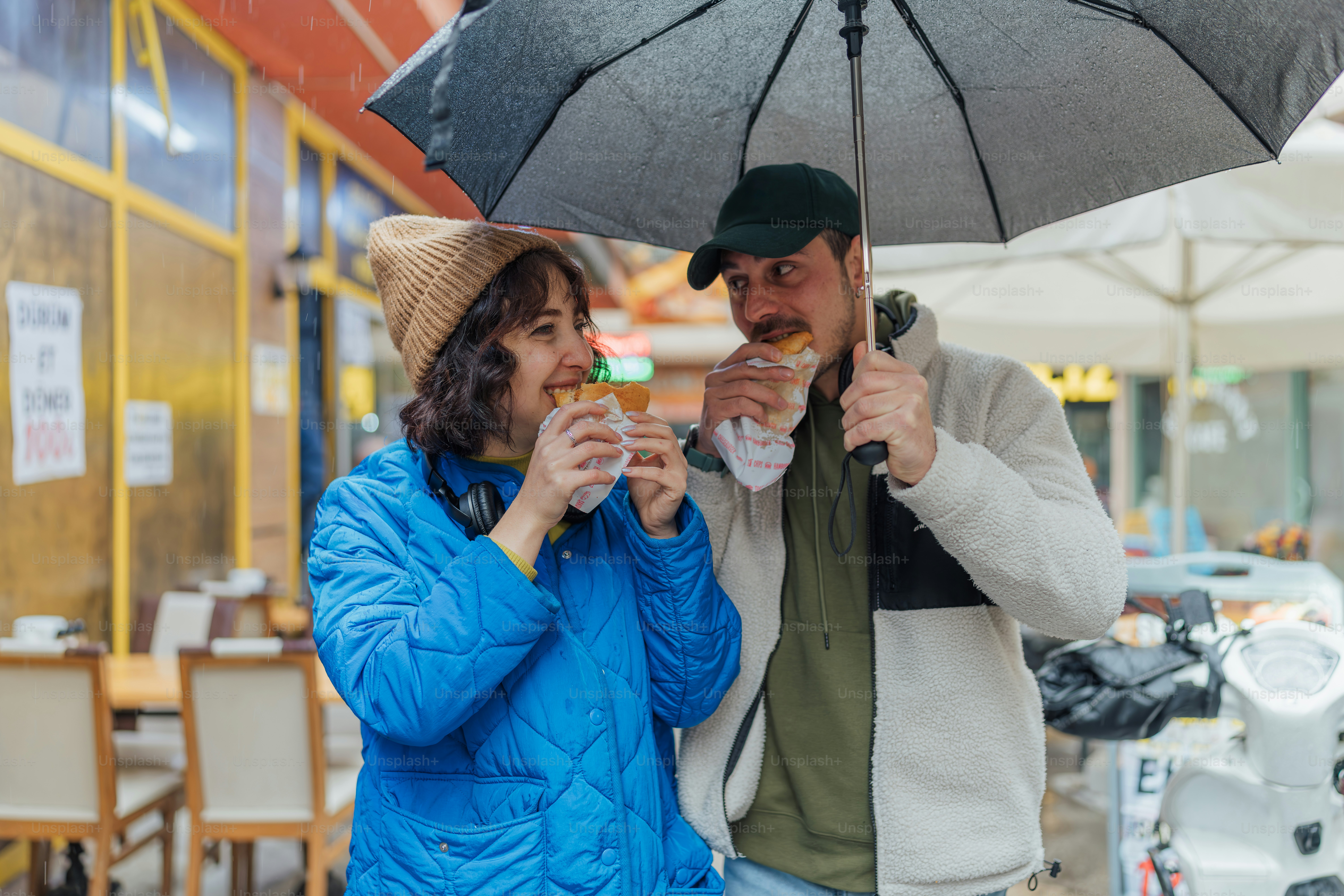 A man and woman standing under an umbrella