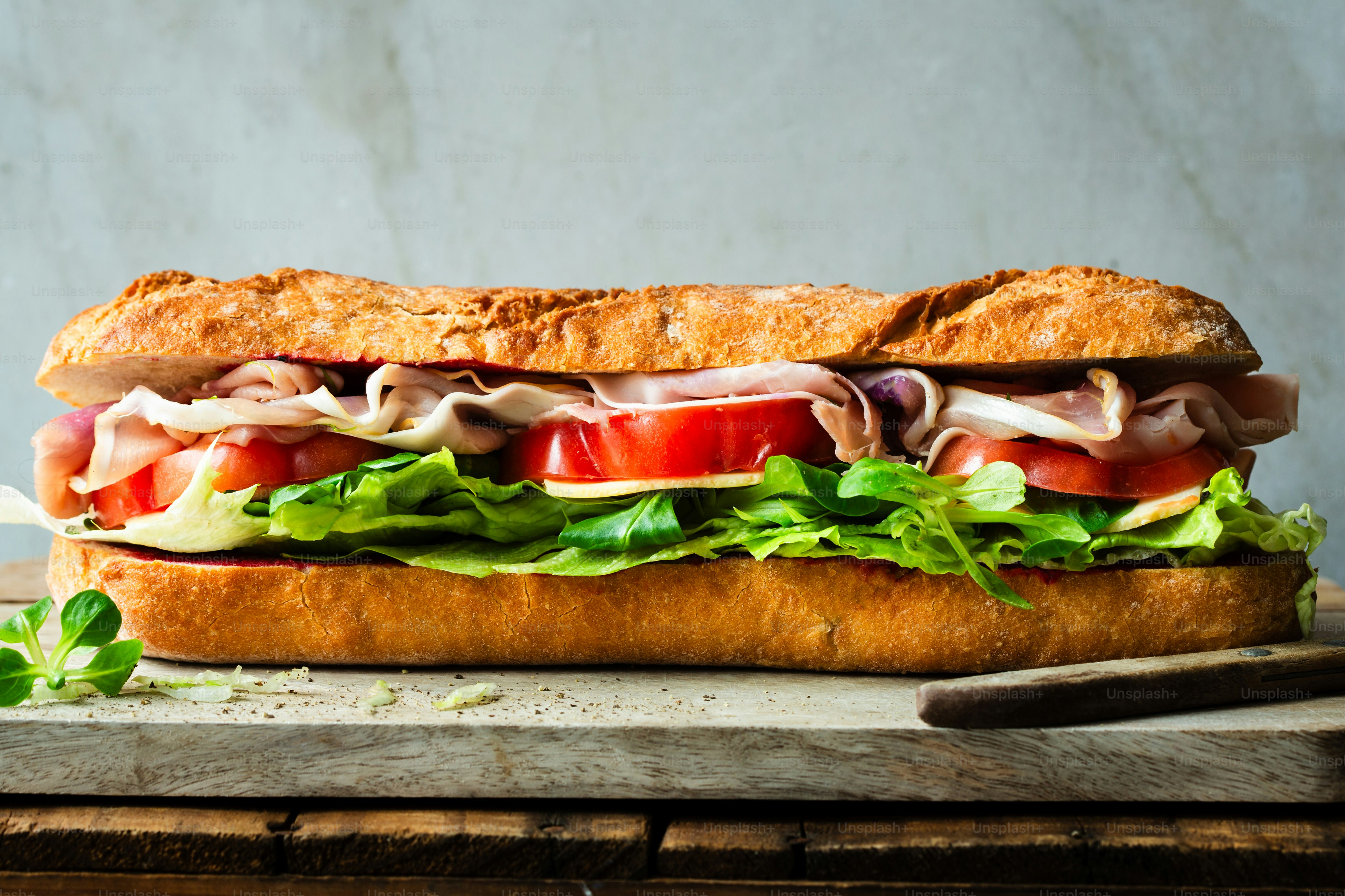 Un sándwich grande con carne, lechuga y tomates