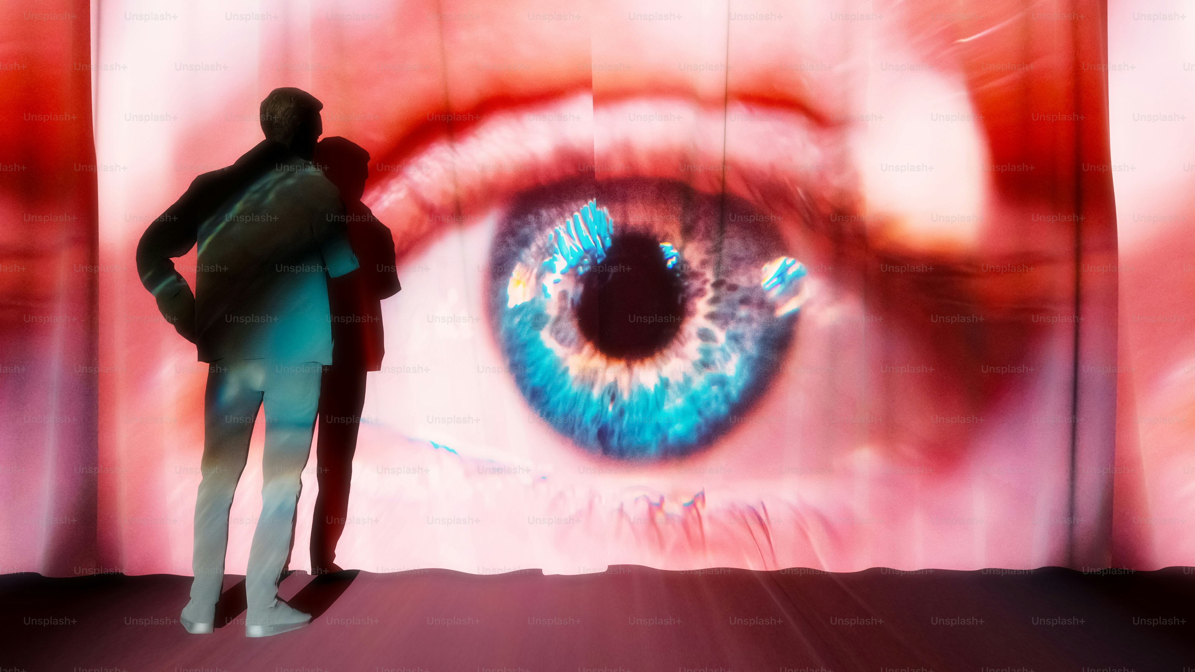 A man standing in front of a large screen with an eye on it