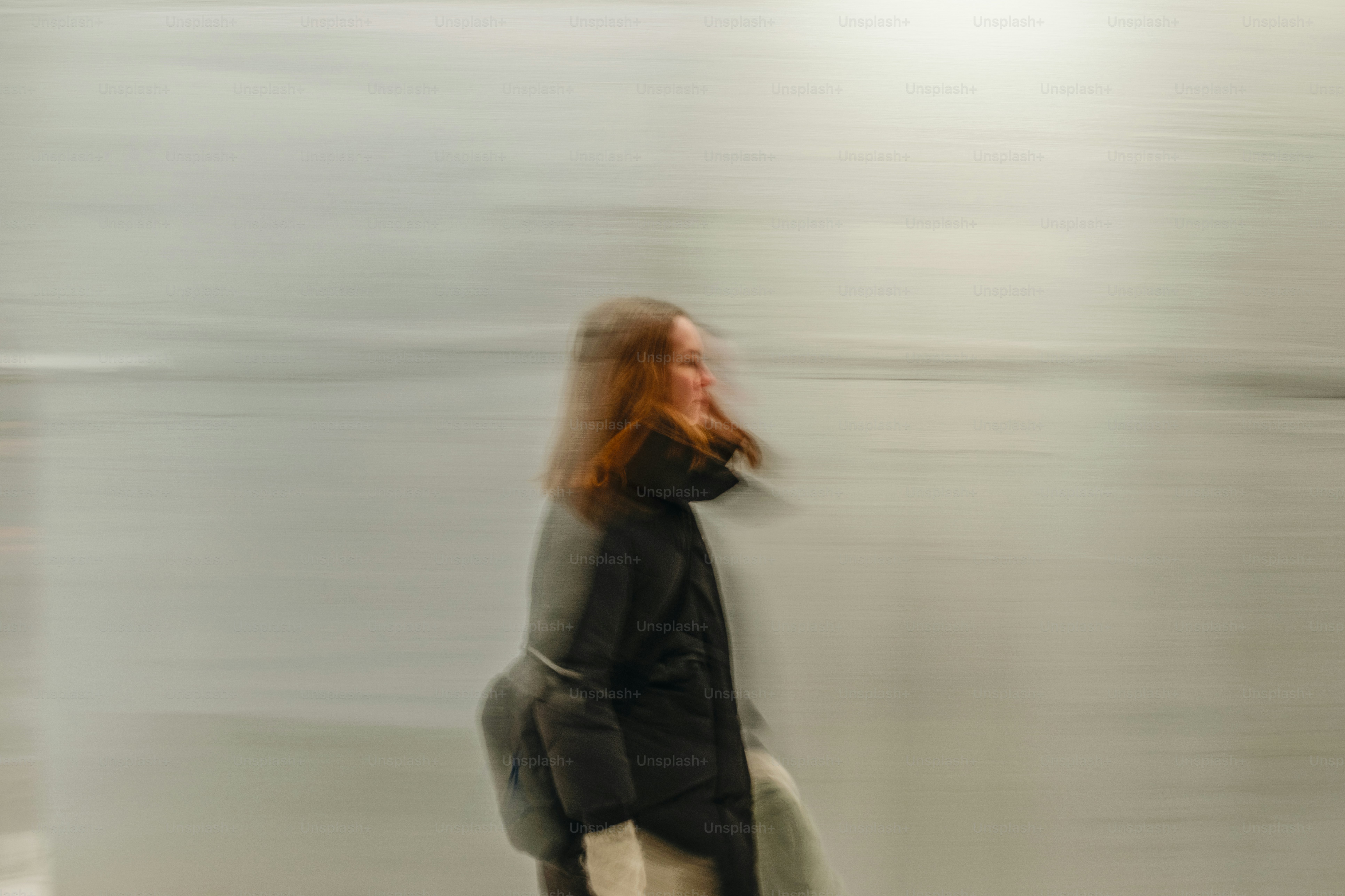 A blurry photo of a woman walking with a surfboard