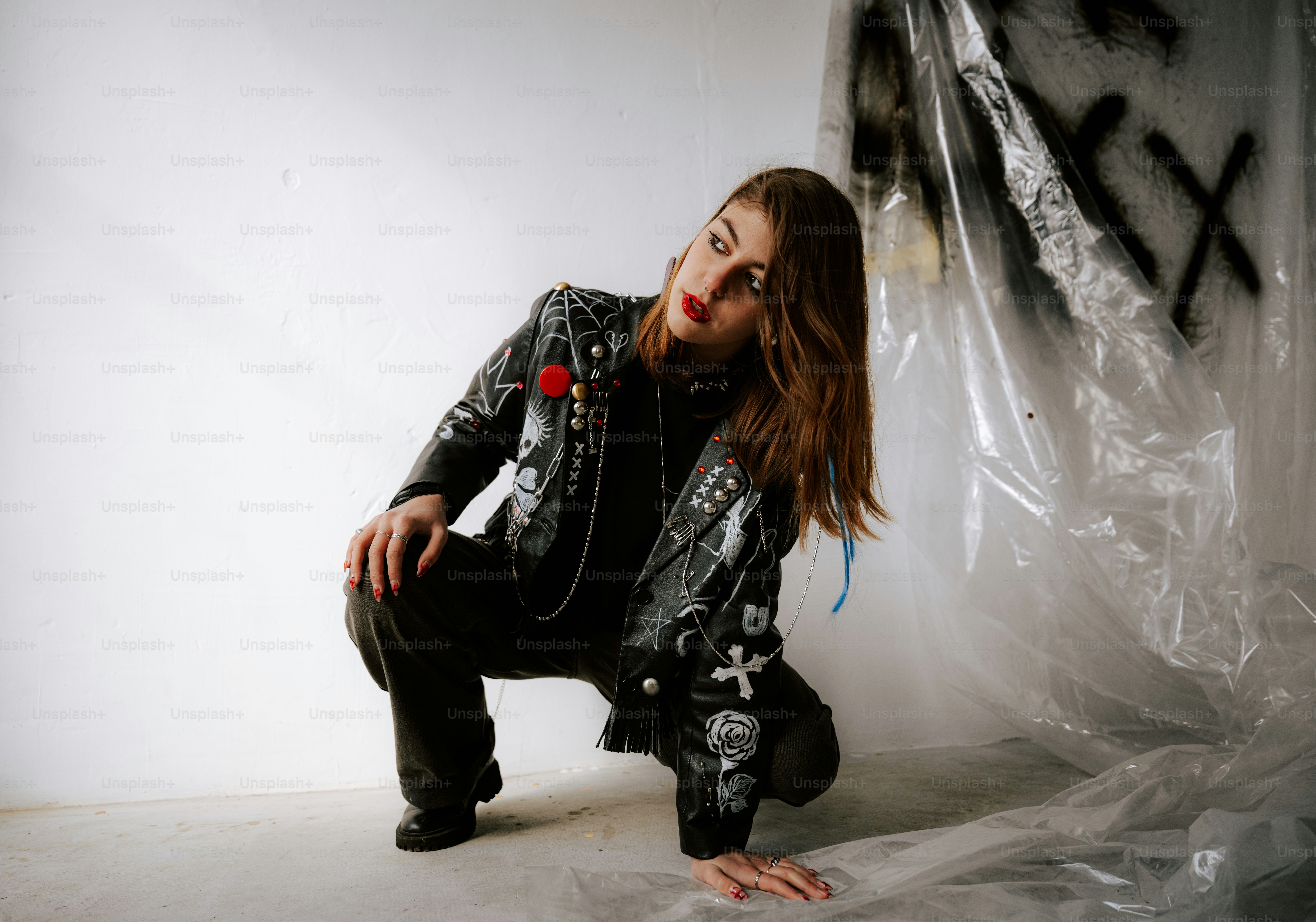 A woman kneeling down in front of a white backdrop
