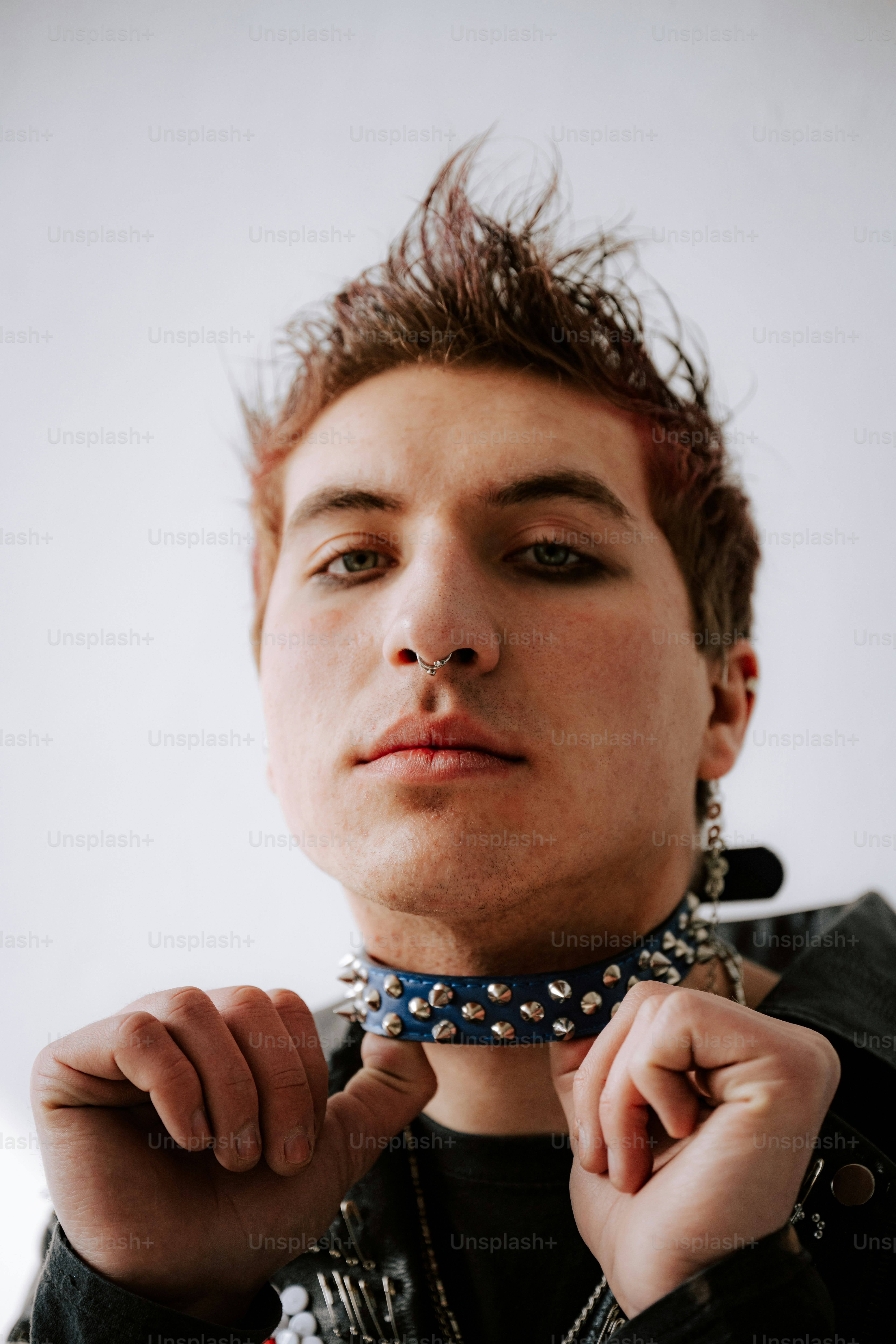 A young man wearing a leather jacket and a choker