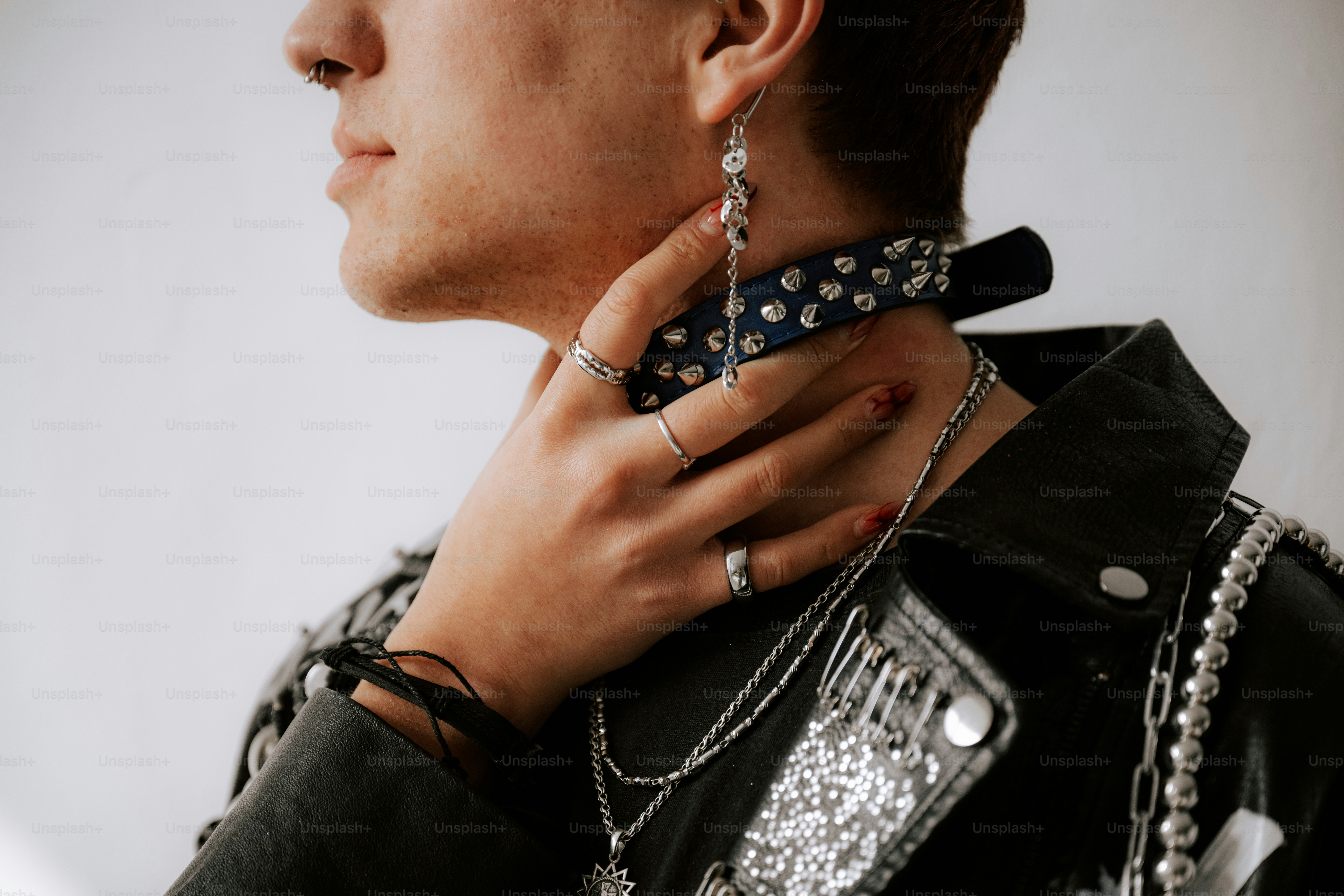 A man wearing a black leather jacket and a chain around his neck