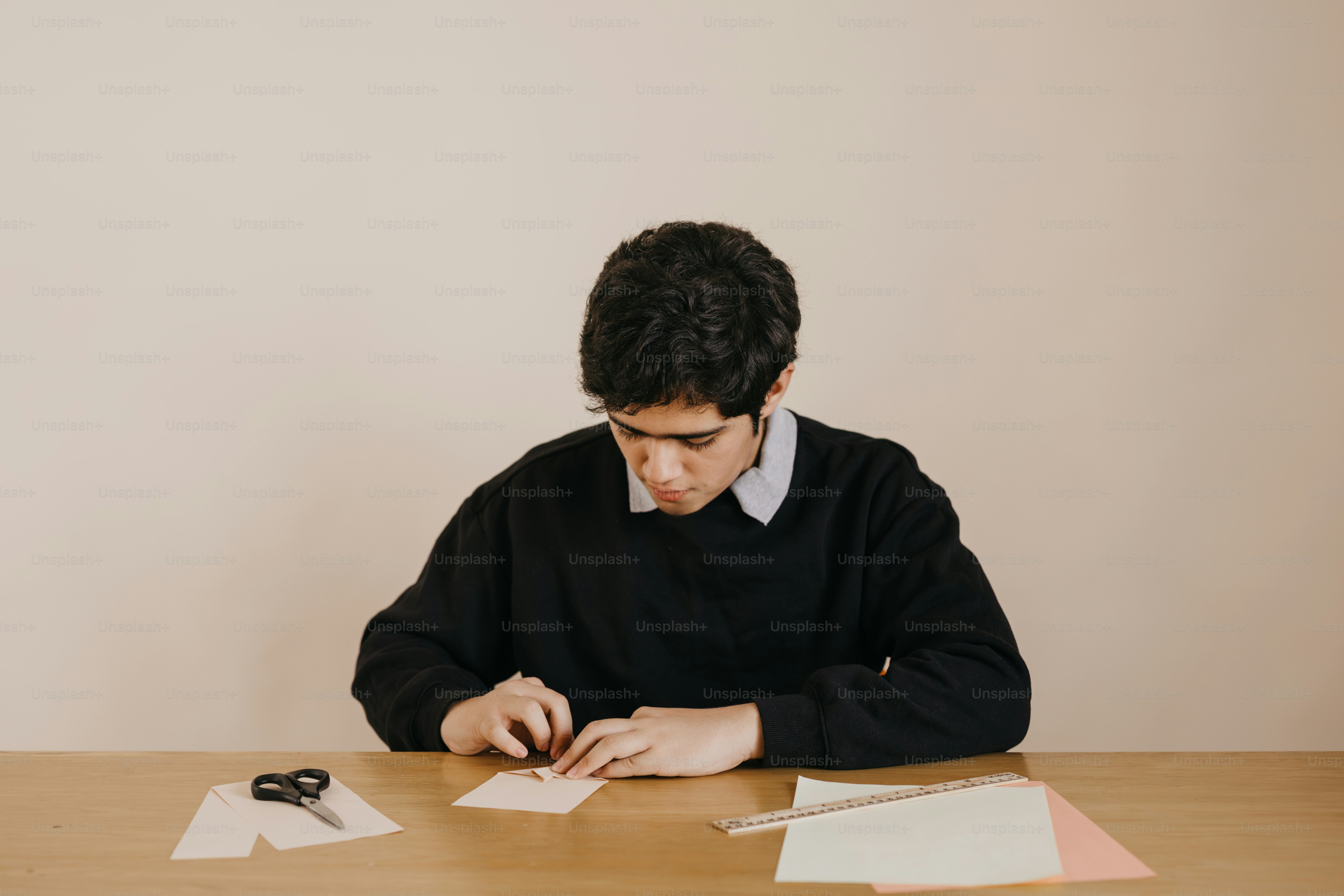 A man sitting at a table with papers and pens