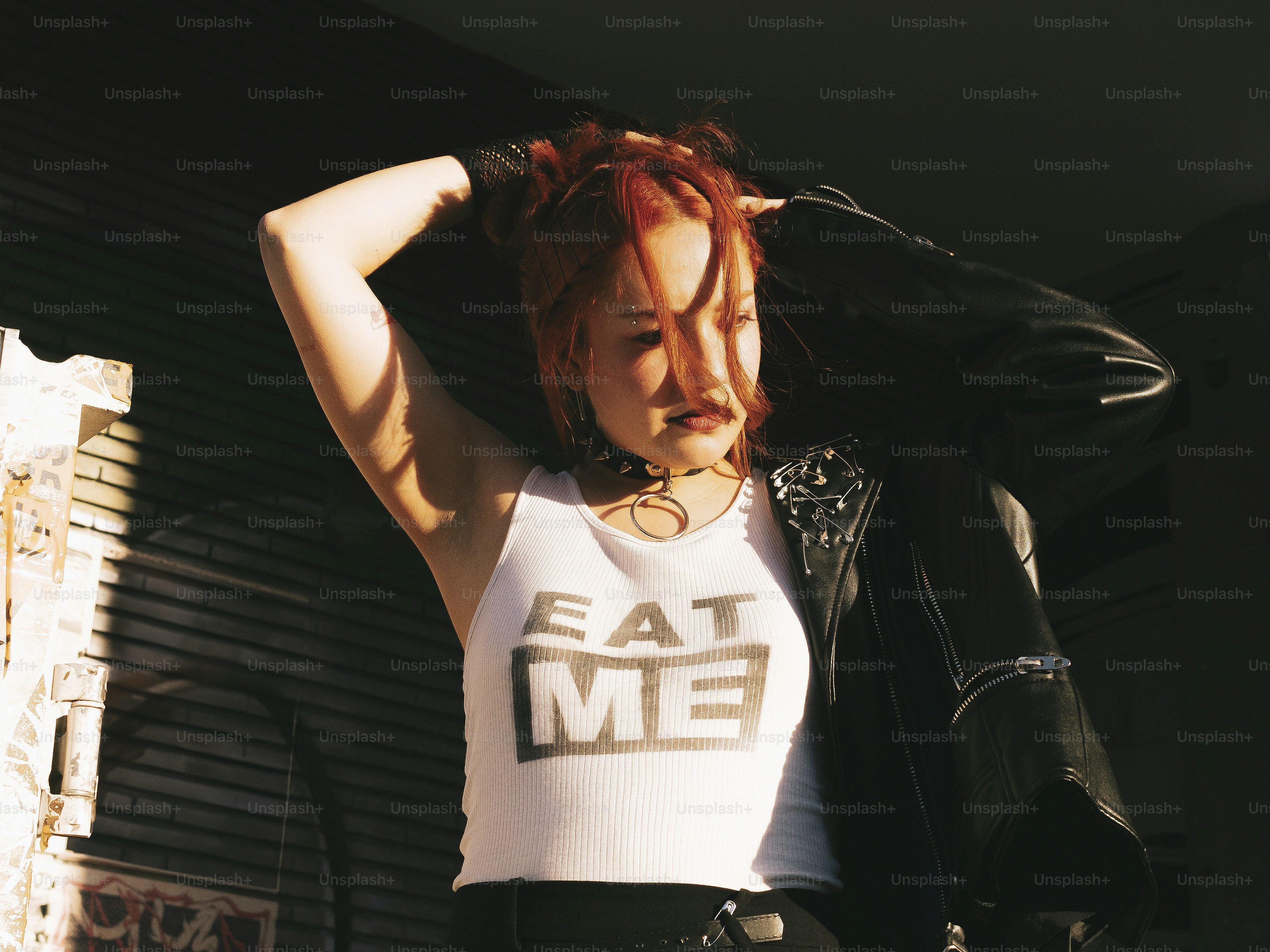 A woman with red hair wearing a white shirt and black pants