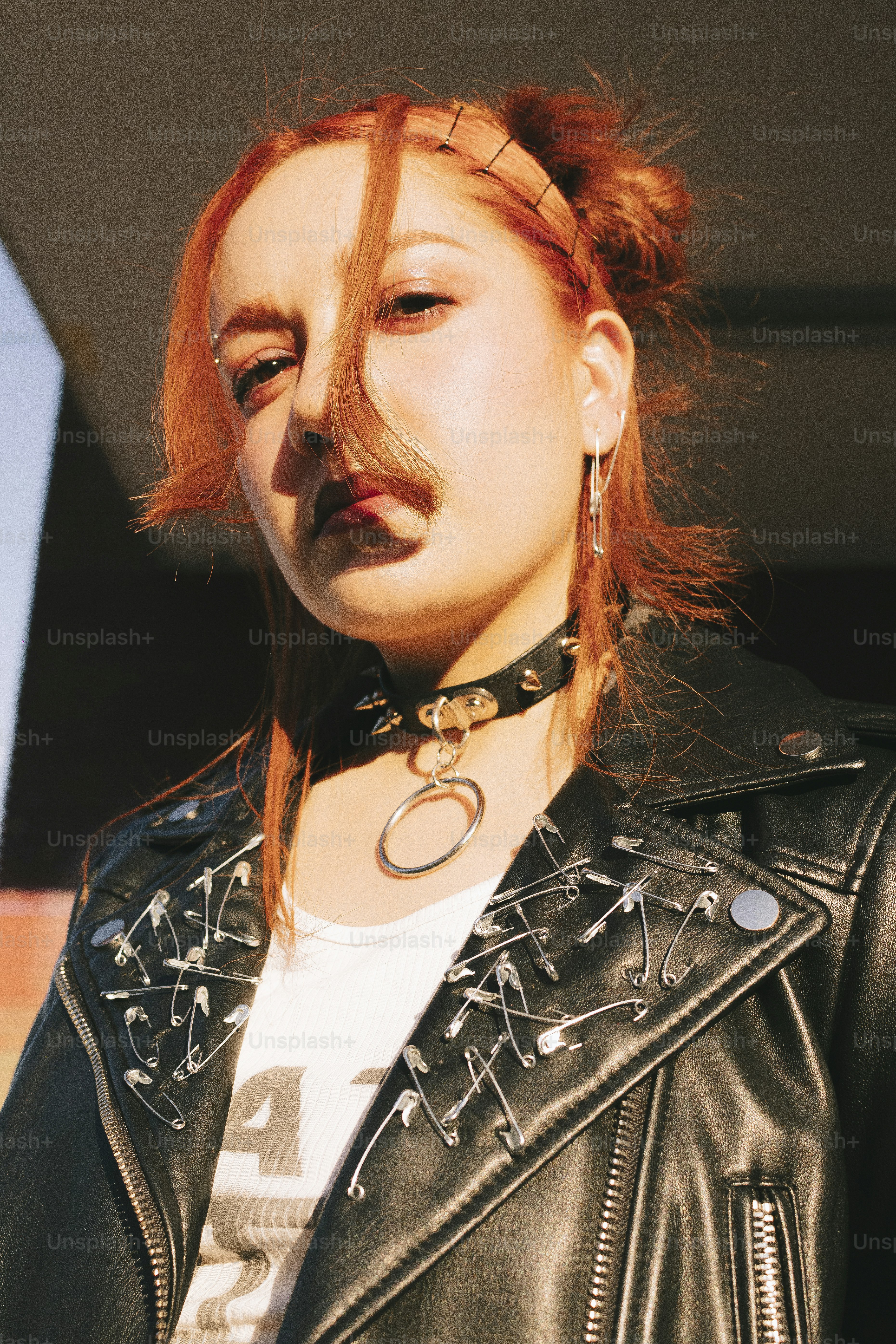 Uma mulher com cabelo vermelho vestindo uma jaqueta de couro preta