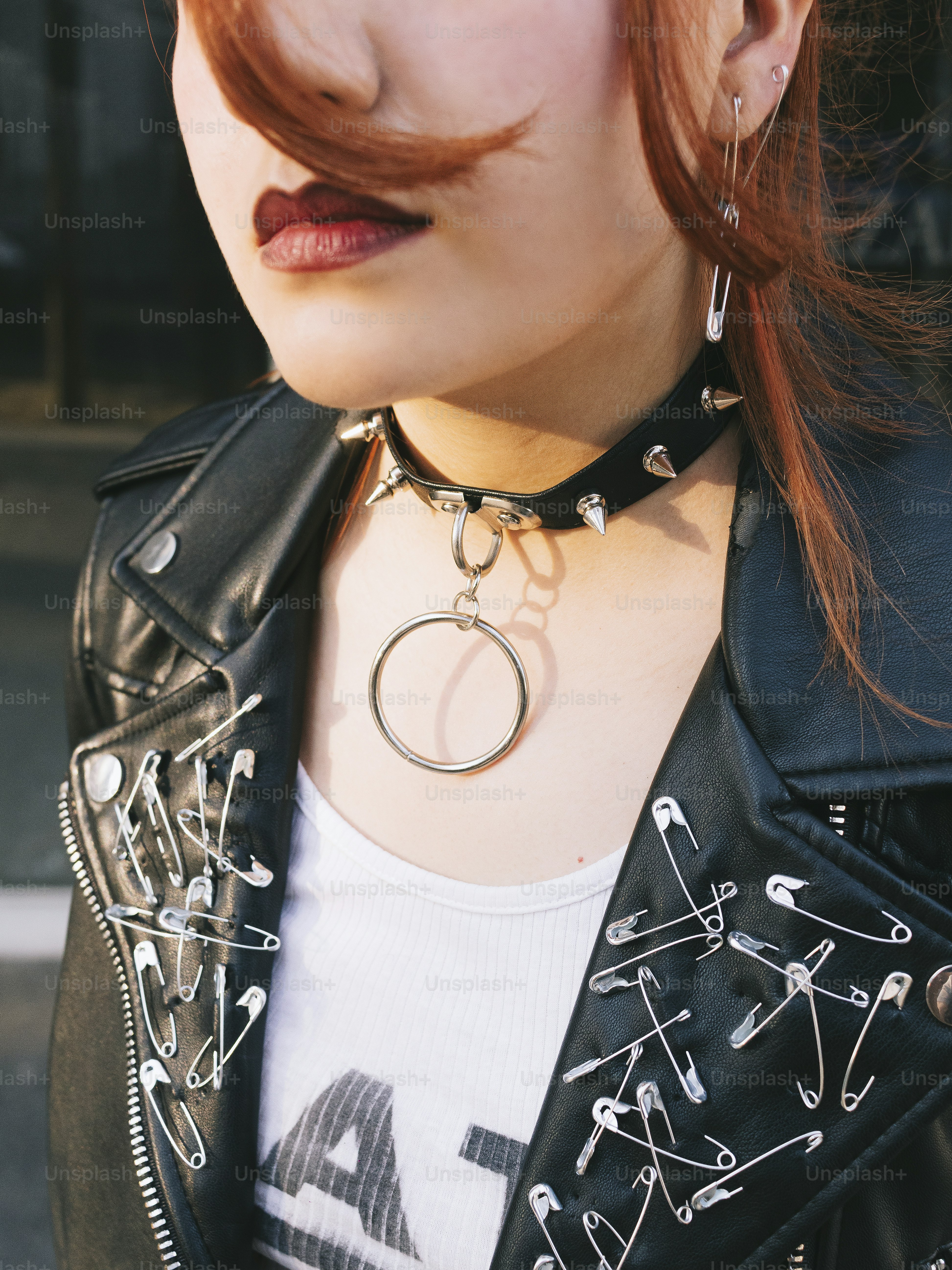 A woman with red hair wearing a black leather jacket