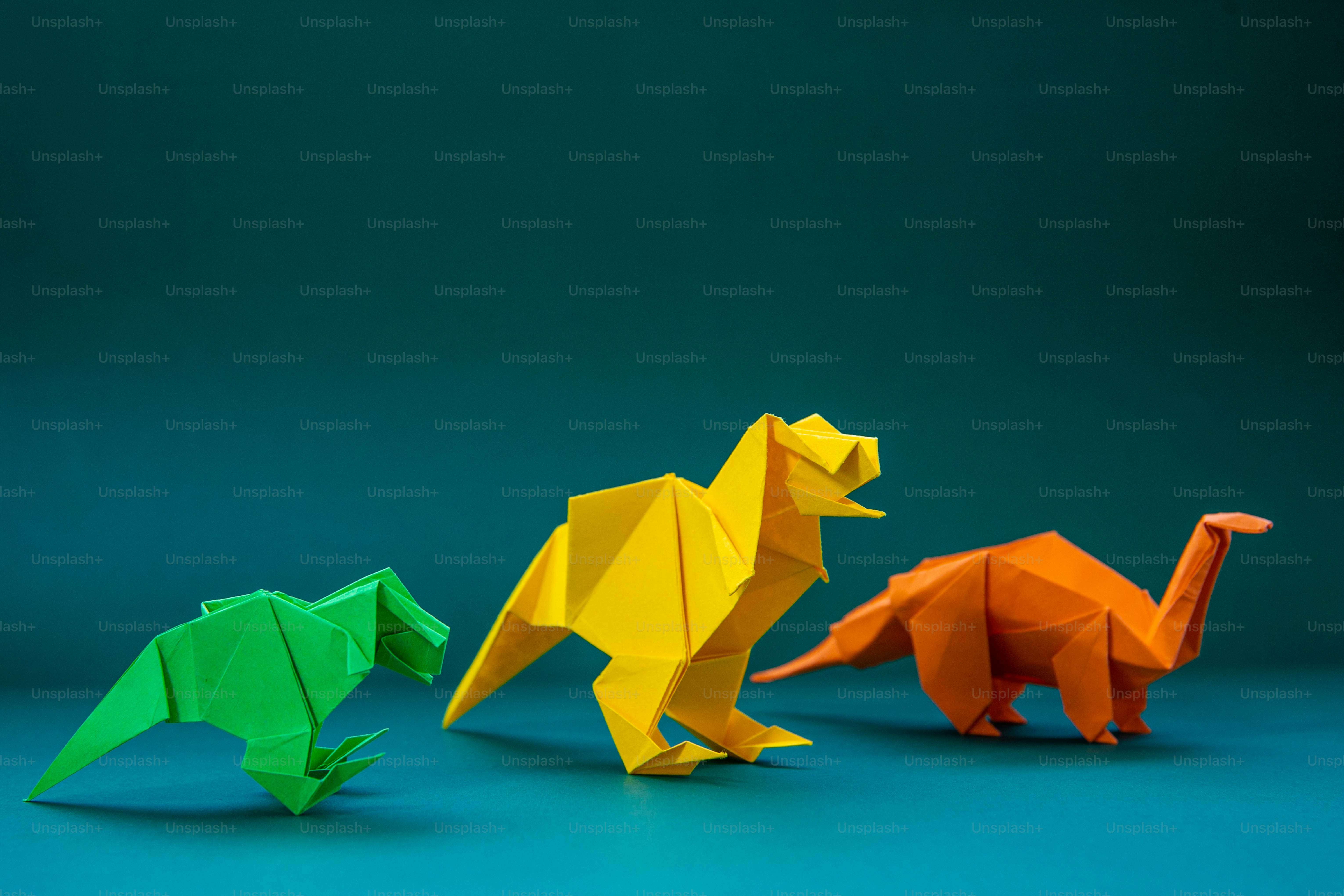 Sekelompok dinosaurus origami dengan latar belakang biru