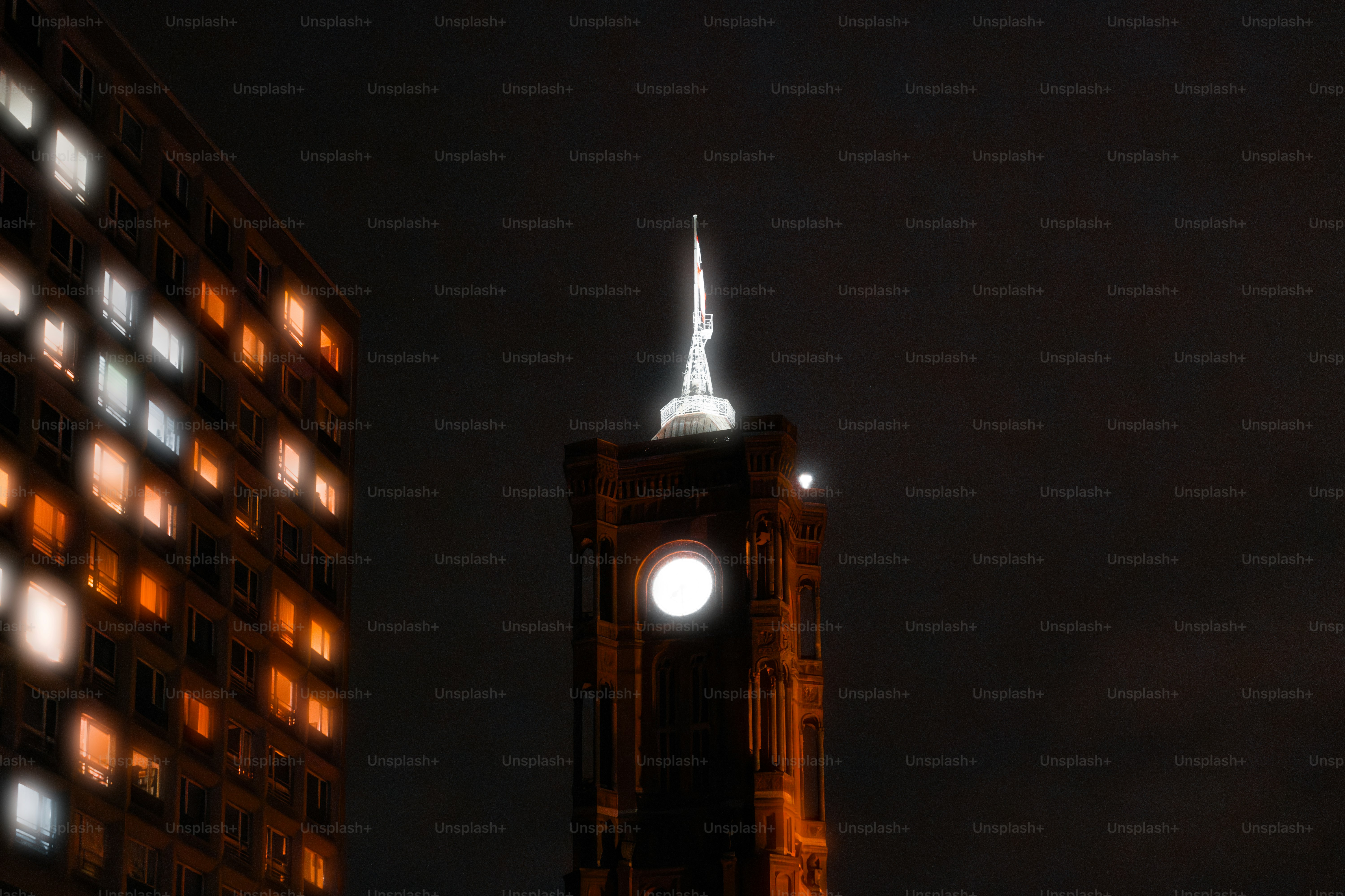 Ein großer Uhrenturm, der nachts über einer Stadt thront