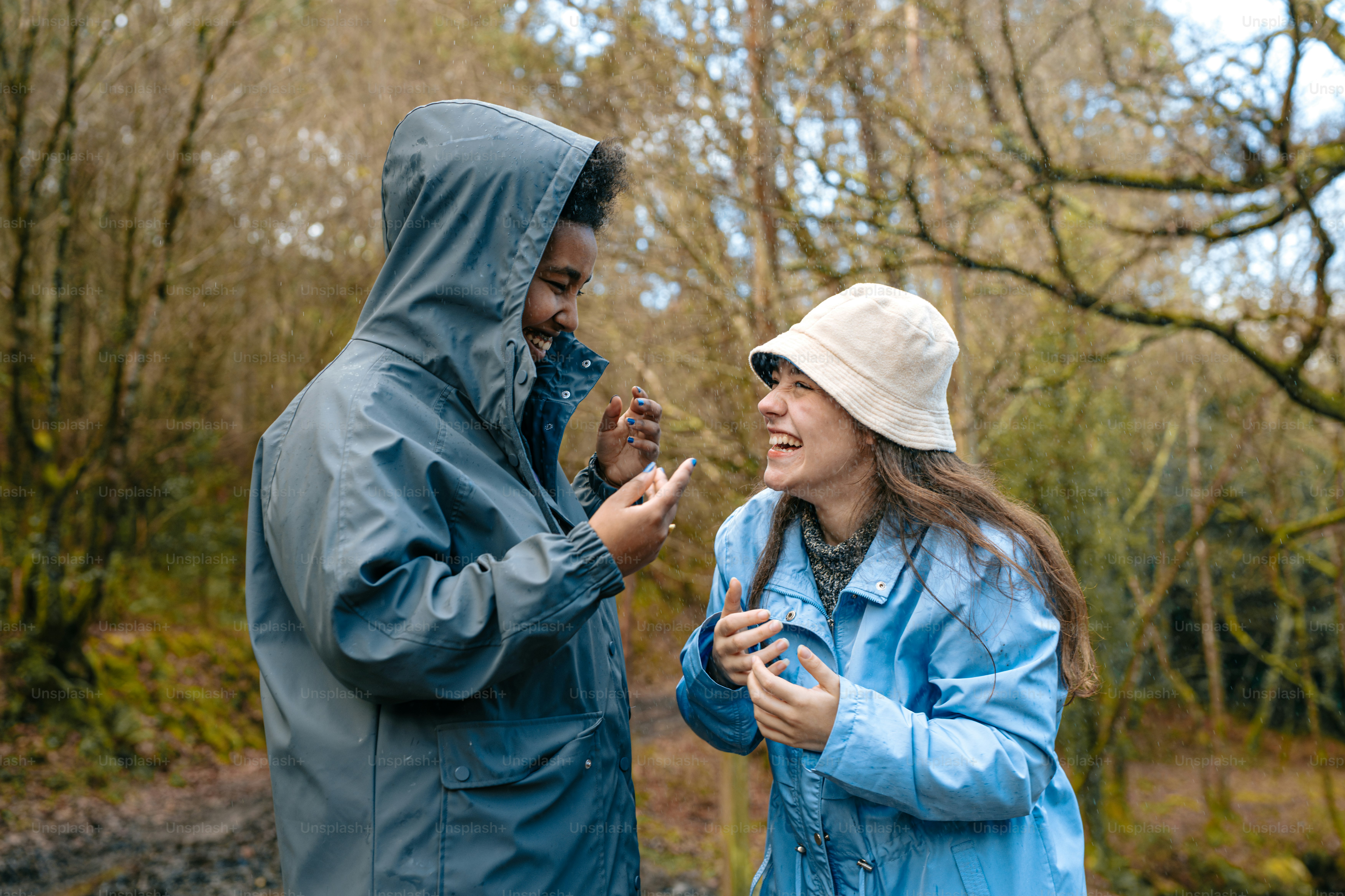 A man and a woman standing next to each other in the woods