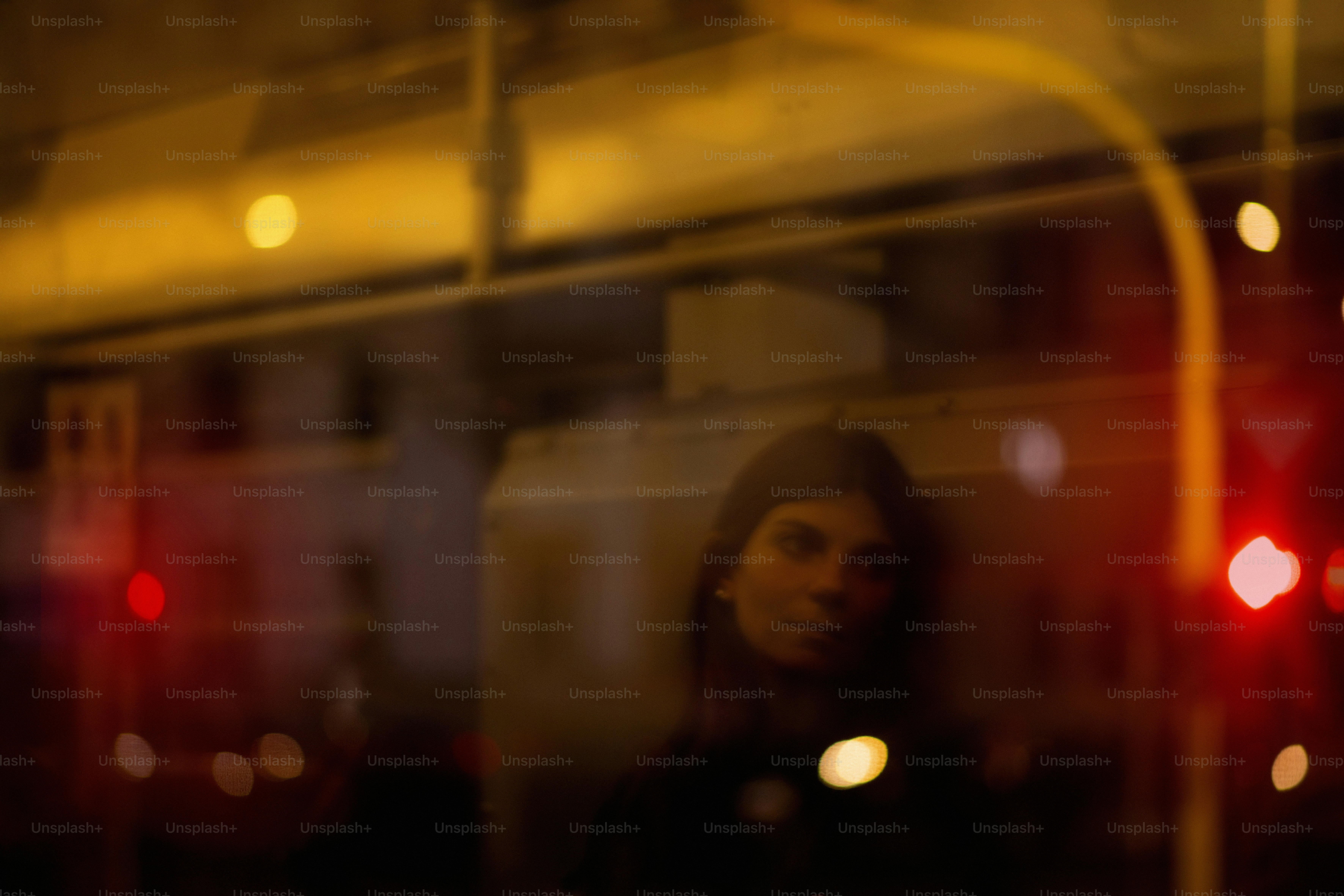 dimly lit train compartment at night with one empty seat and a shadowy figure reflected faintly in the window