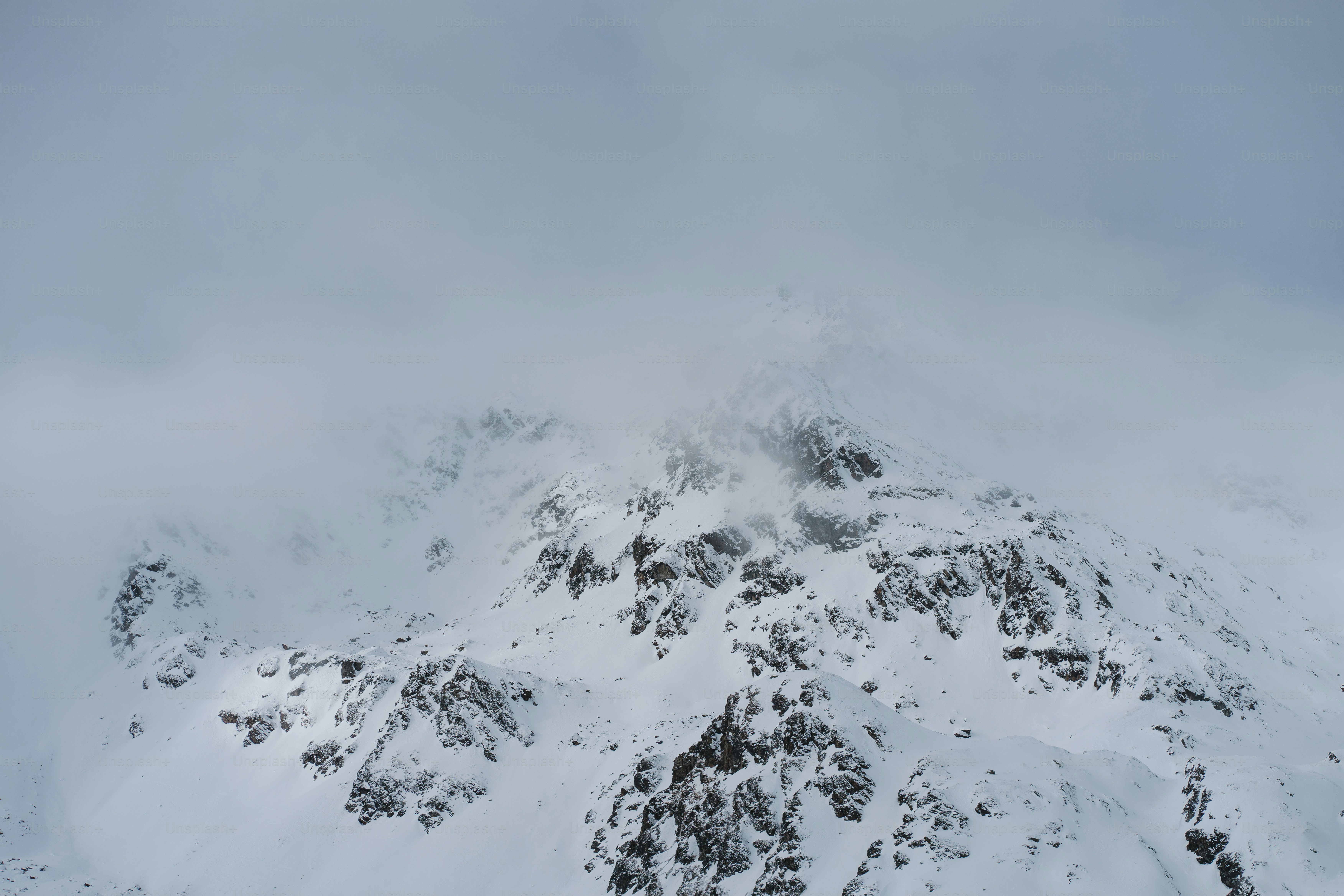 Una montagna ricoperta di neve con uno sfondo di cielo
