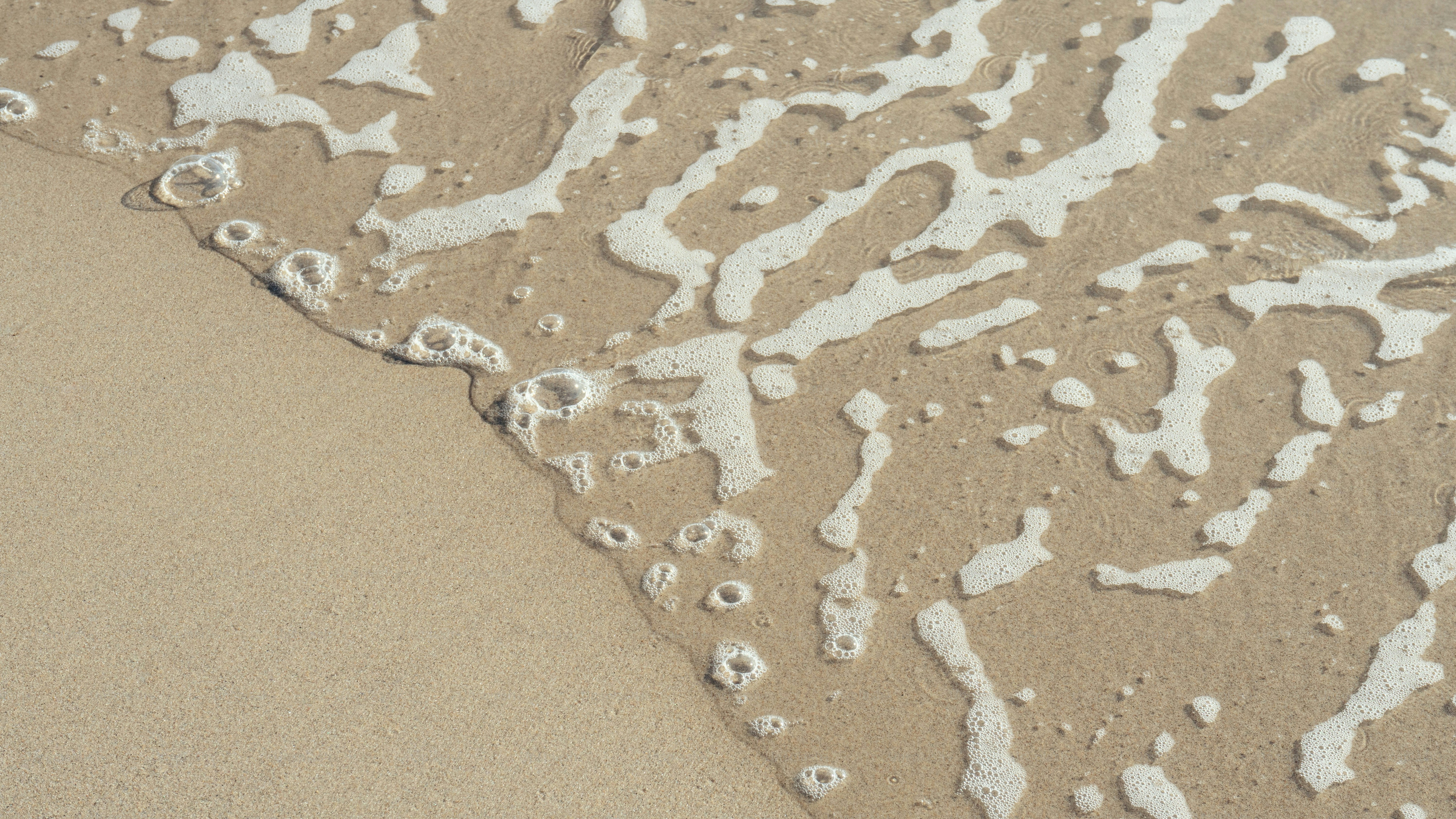 Un primer plano de la arena y el agua en una playa