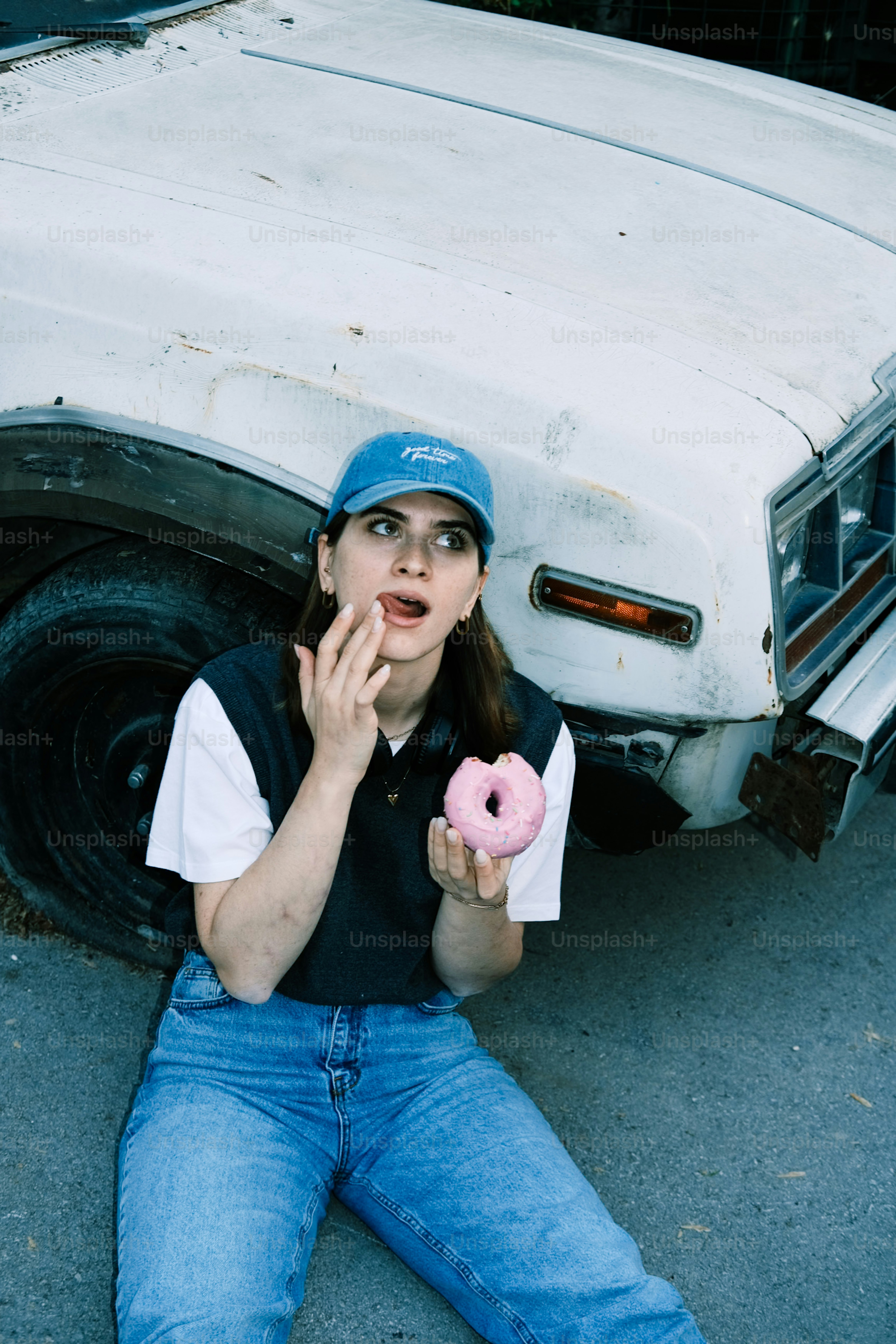 A woman sitting on the ground eating a doughnut