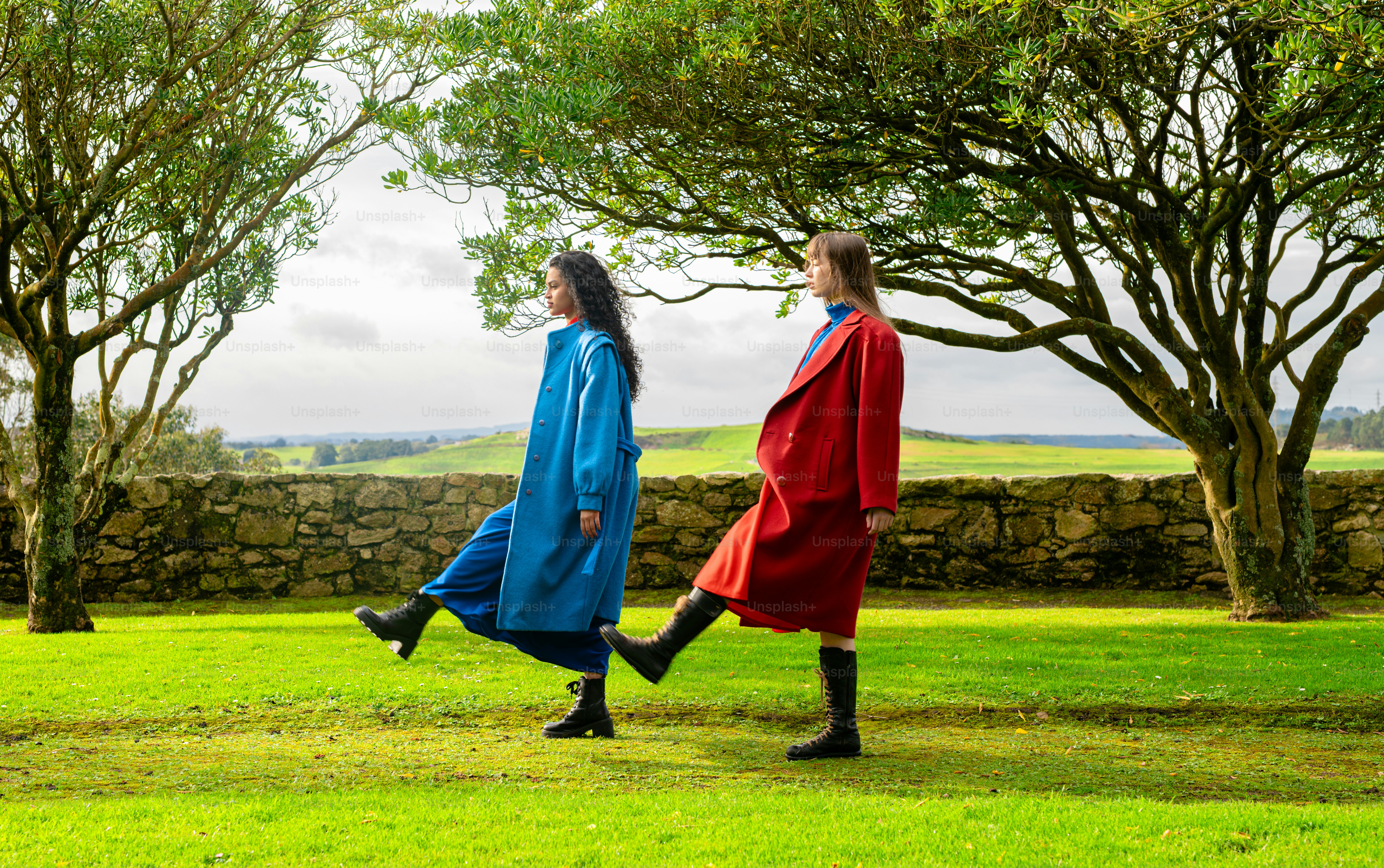 A couple of women walking across a lush green field