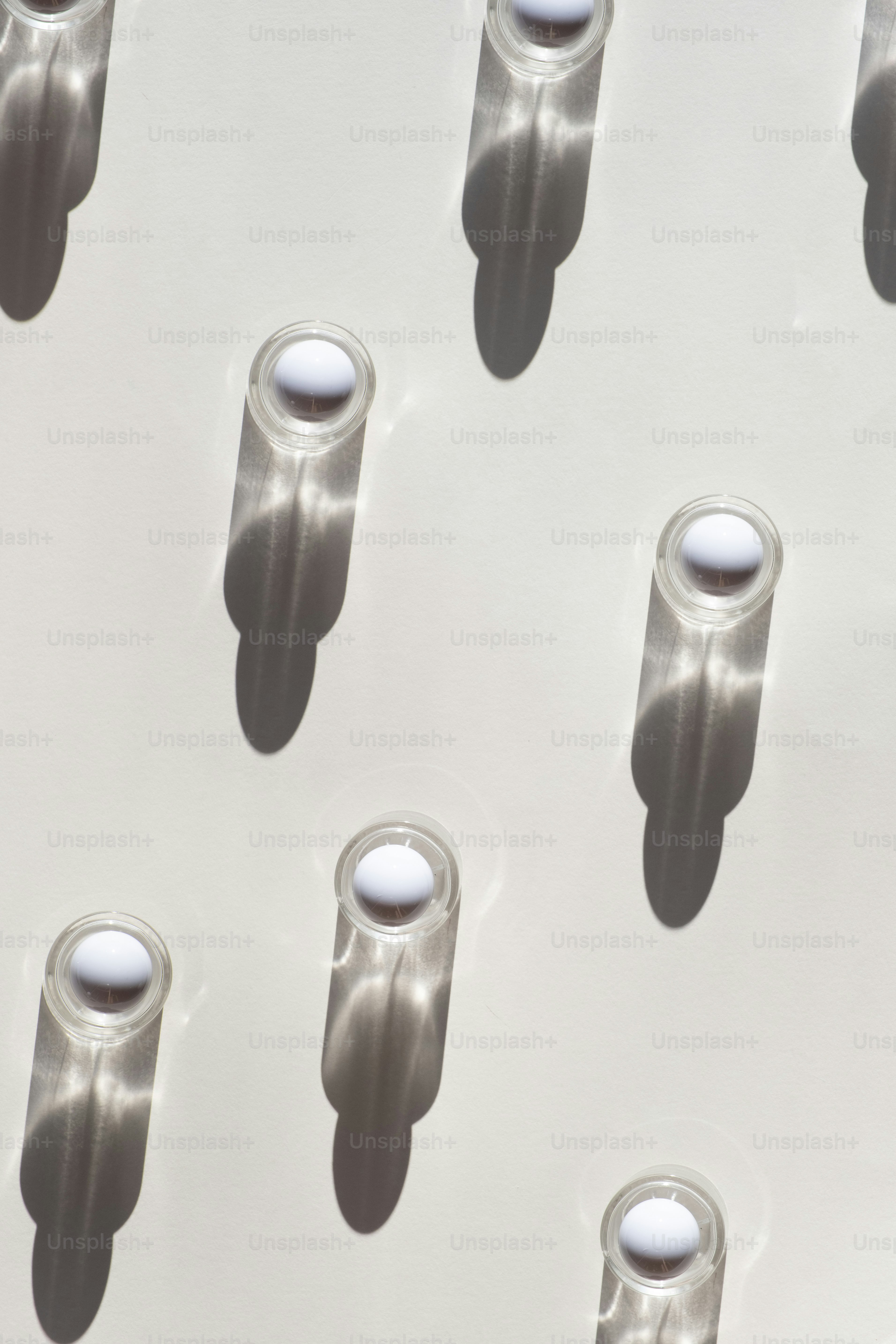 A group of white objects on a white surface photo – Perfume bottle ...