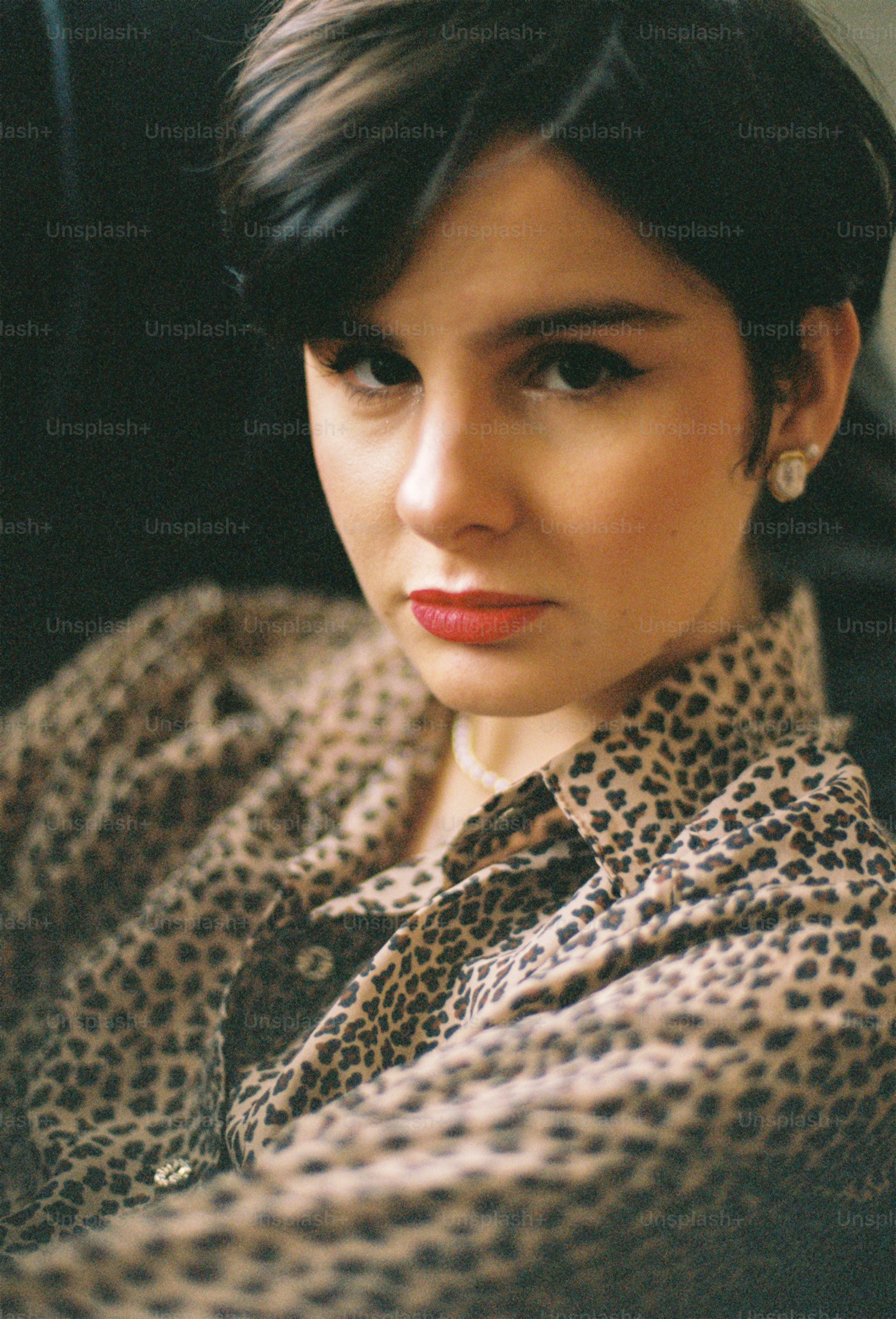 A woman with short hair wearing a leopard print shirt