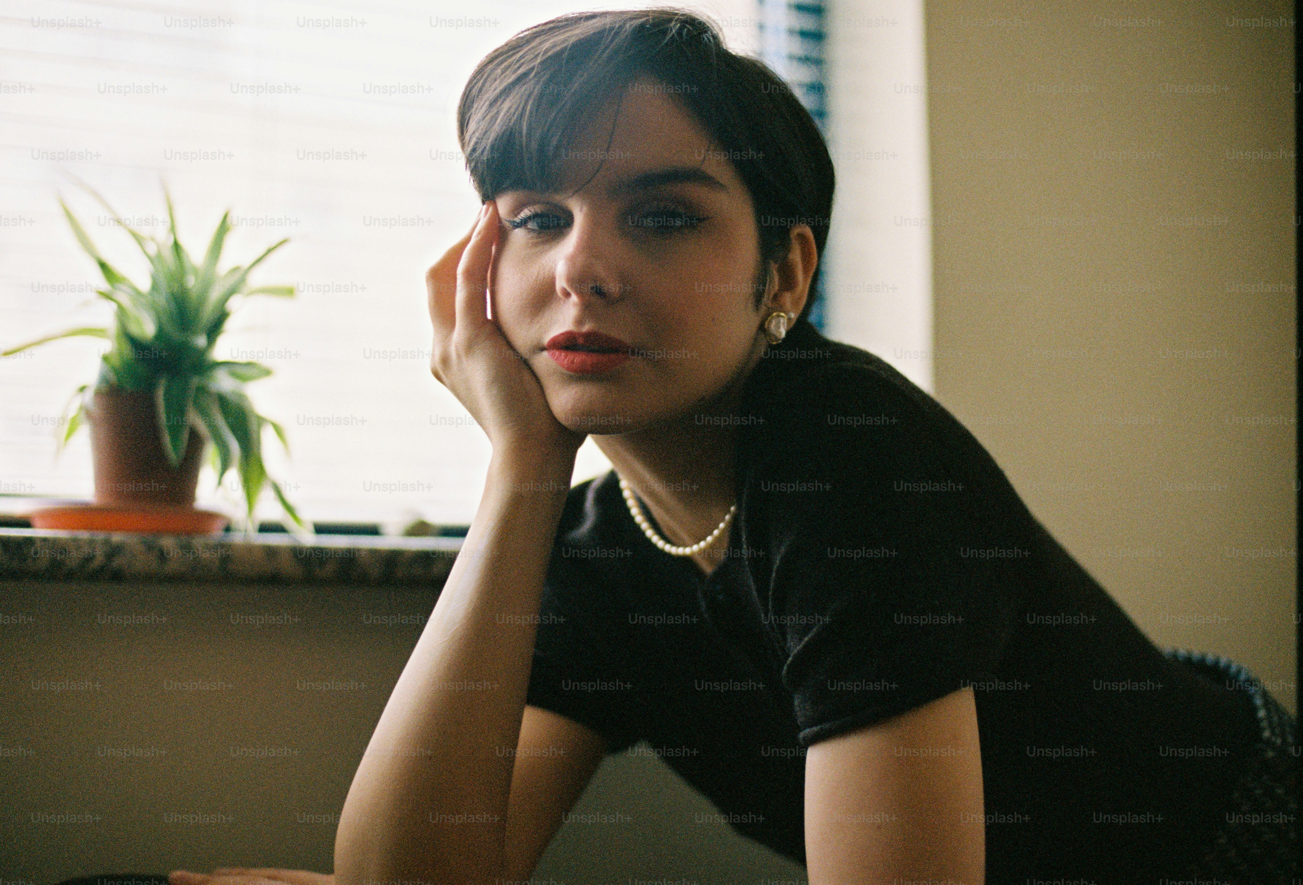 um, mulher, sentando, frente, um, janela, ao lado, um, vaso de plantas