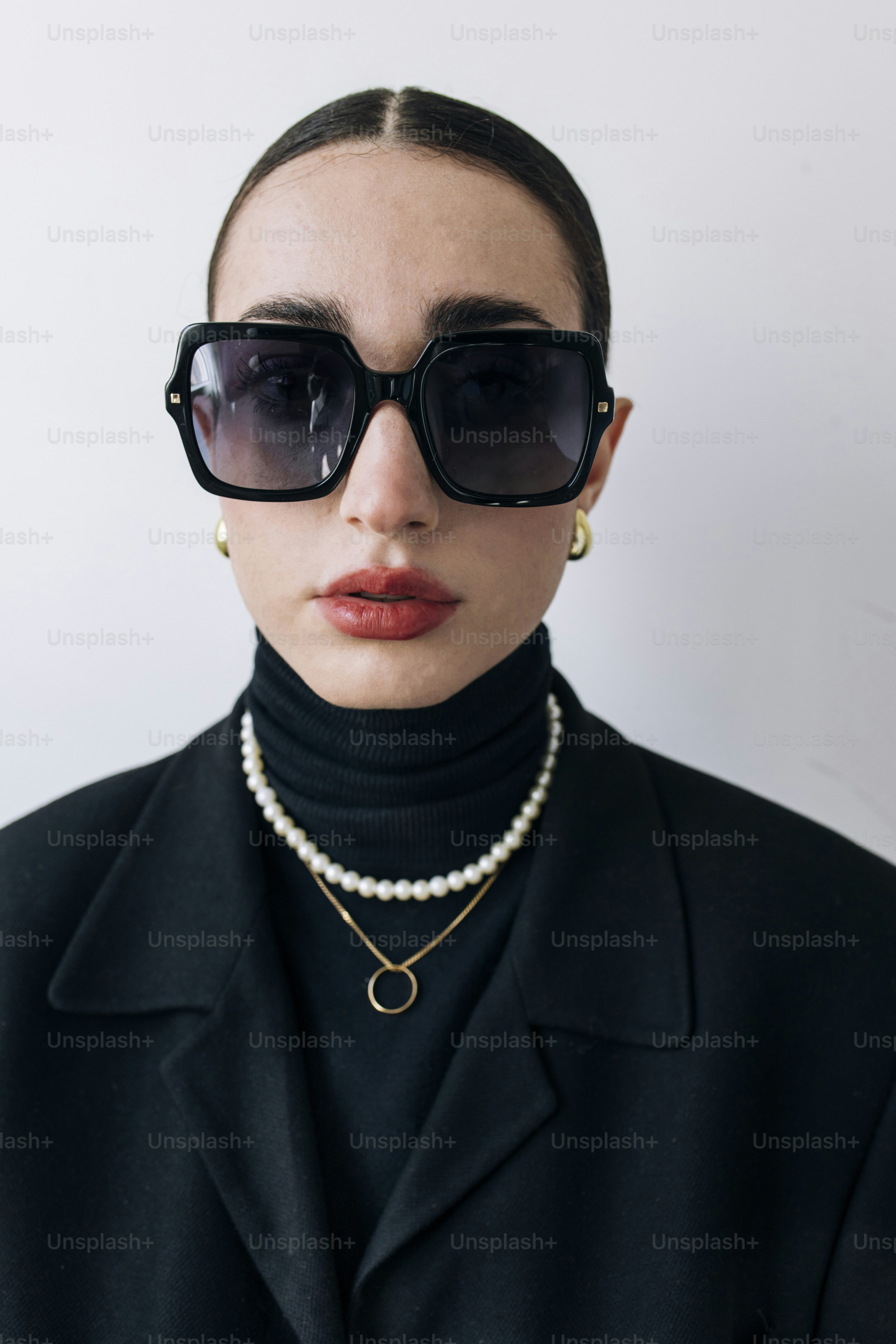 Eine Frau in einem schwarzen Mantel und Perlen