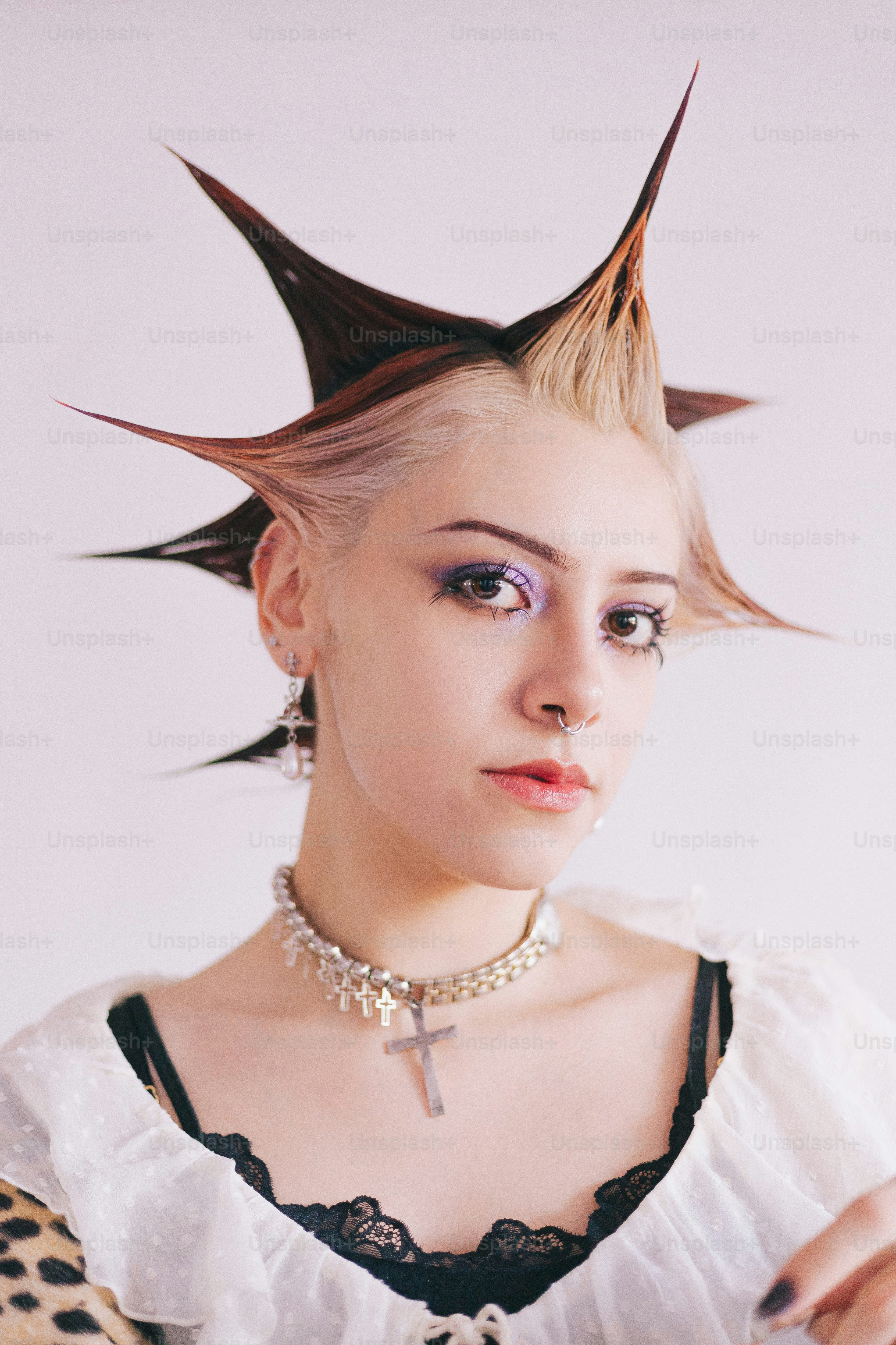 Una donna con i capelli a spillo che indossa una camicetta bianca