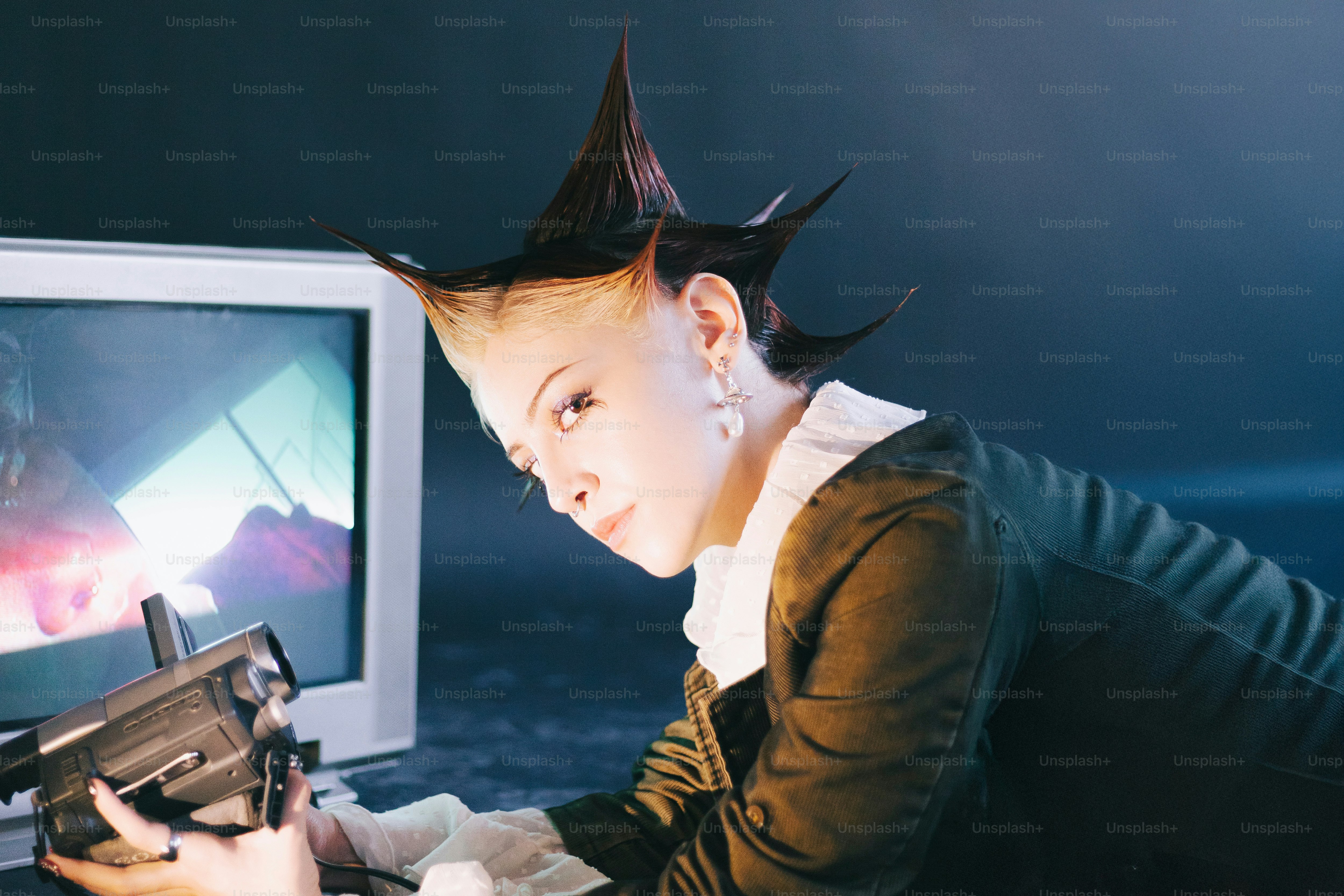 Una donna tiene in mano una pistola e guarda lo schermo di un computer
