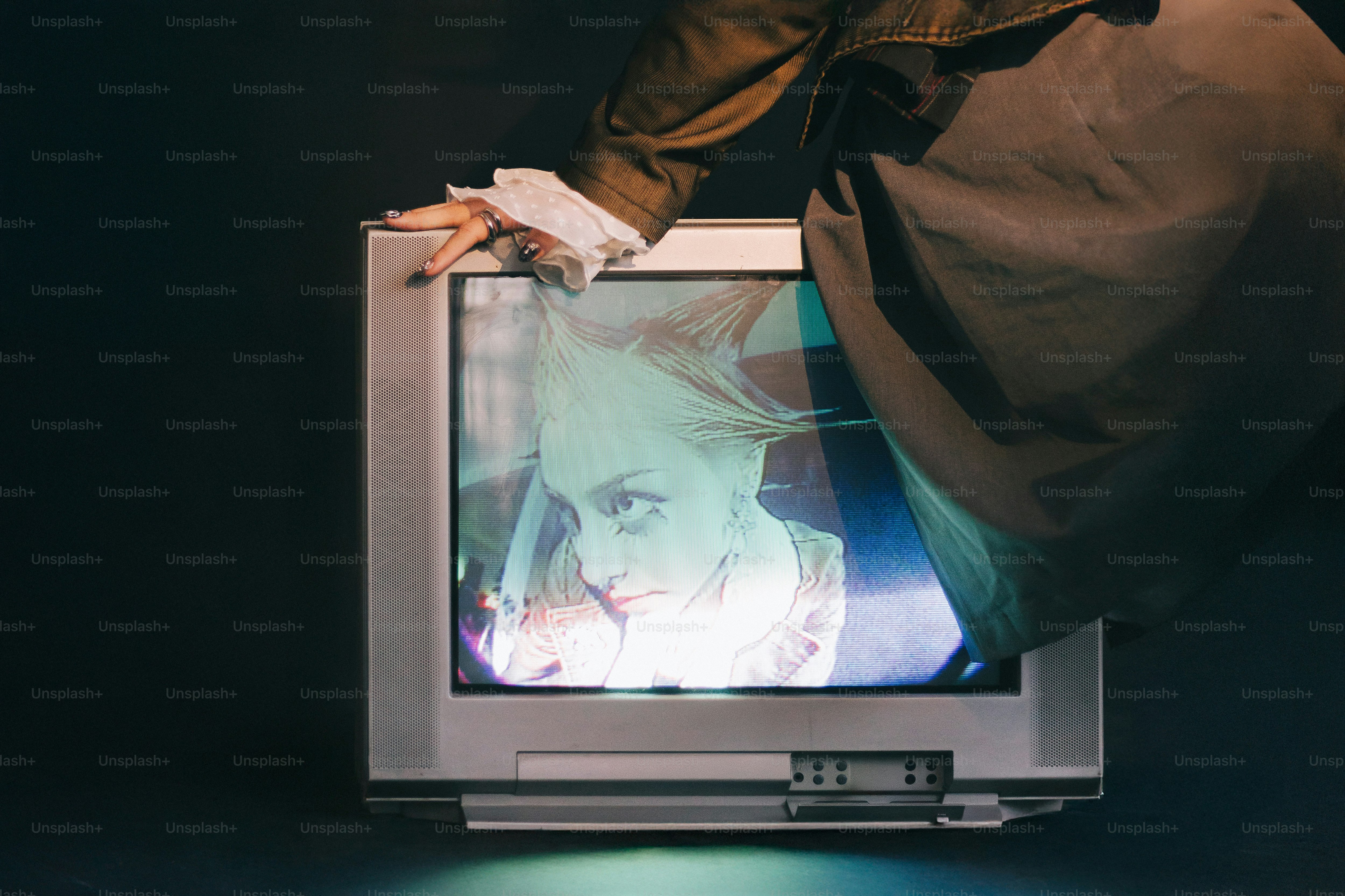 A man standing on a laptop computer with a picture of a woman on the screen