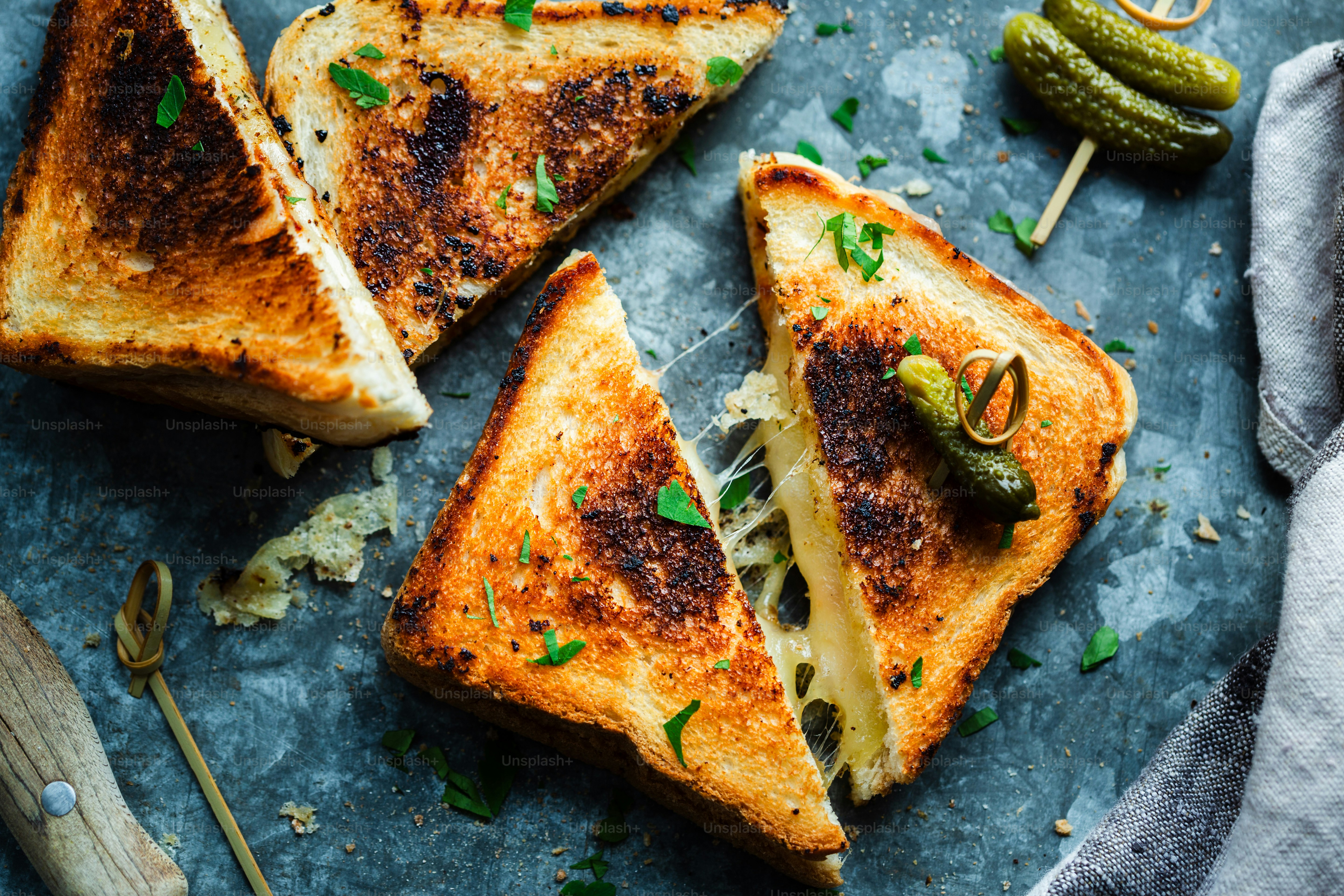 A grilled cheese sandwich with pickles on the side