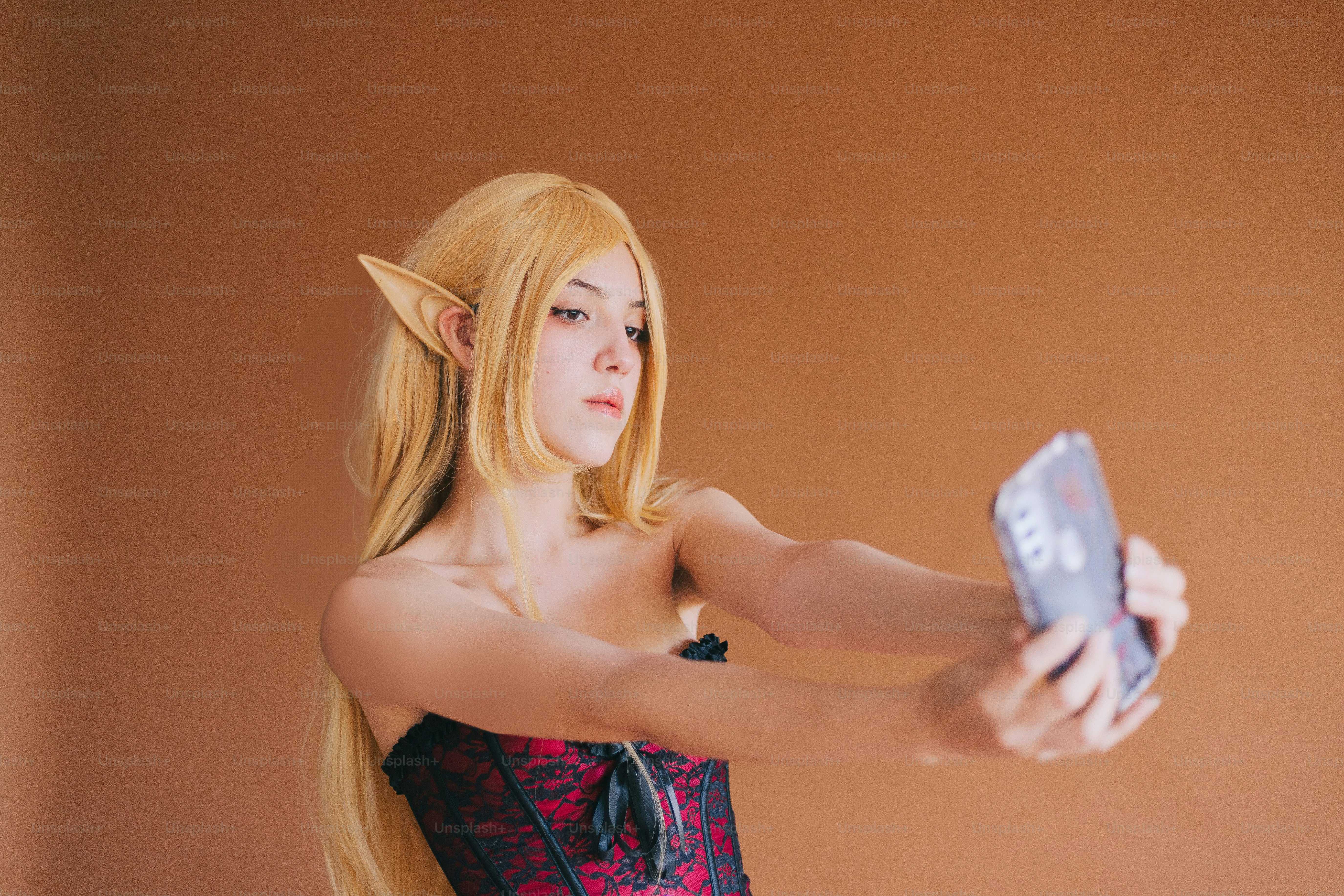 Seorang wanita bercosplay memegang ponsel