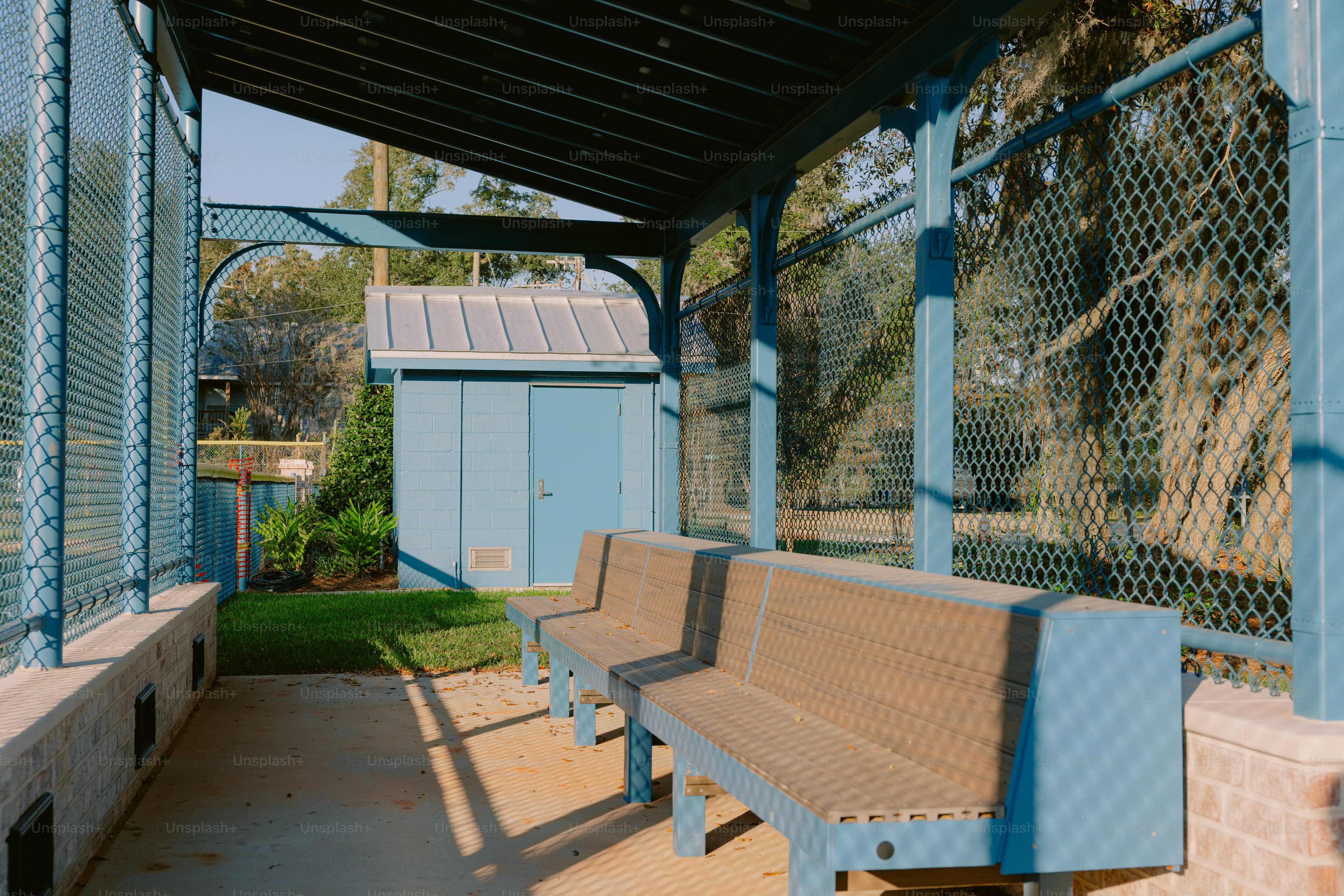 Una panca di legno seduta sotto un tetto di metallo