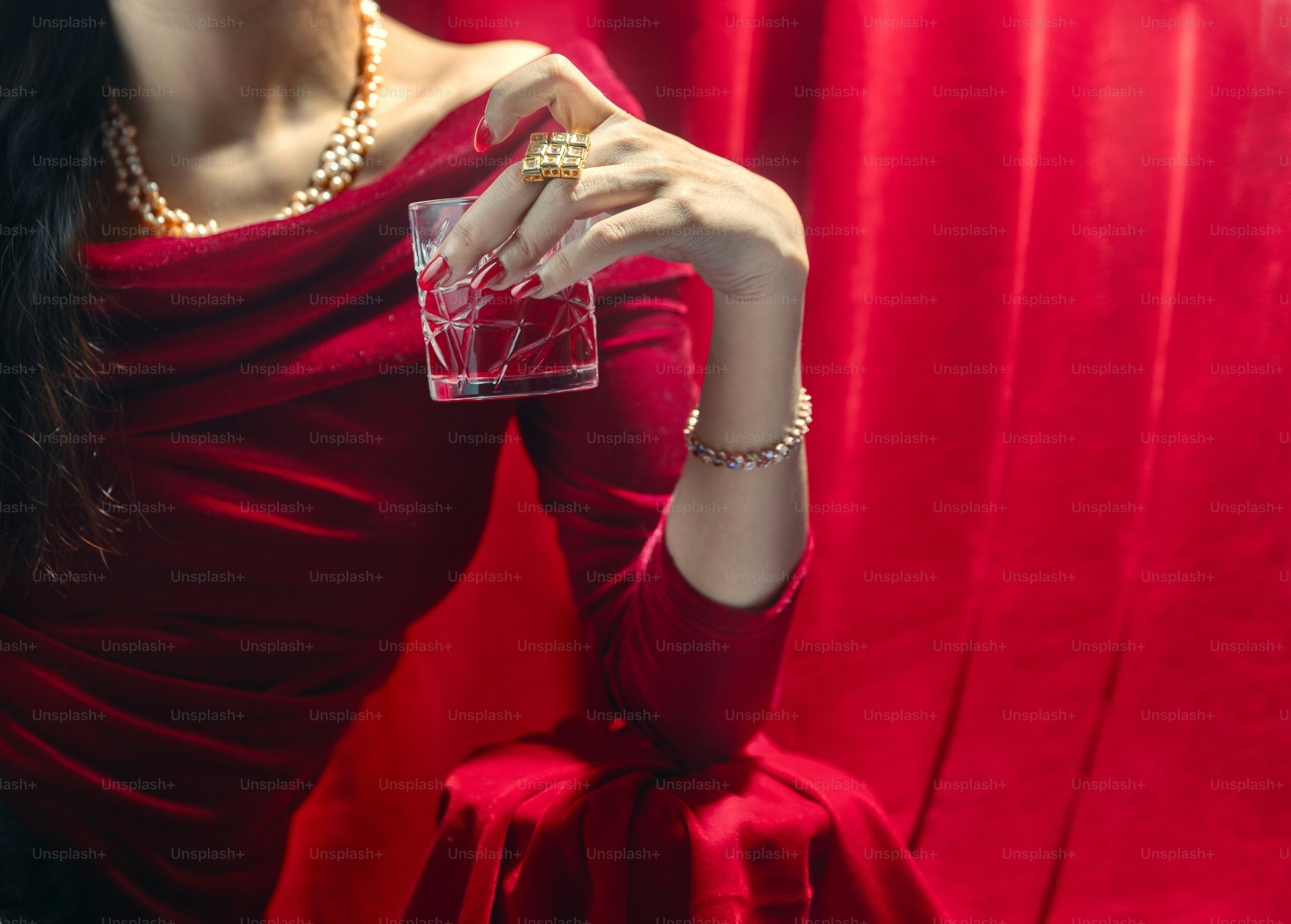 A woman in a red dress holding a playing card