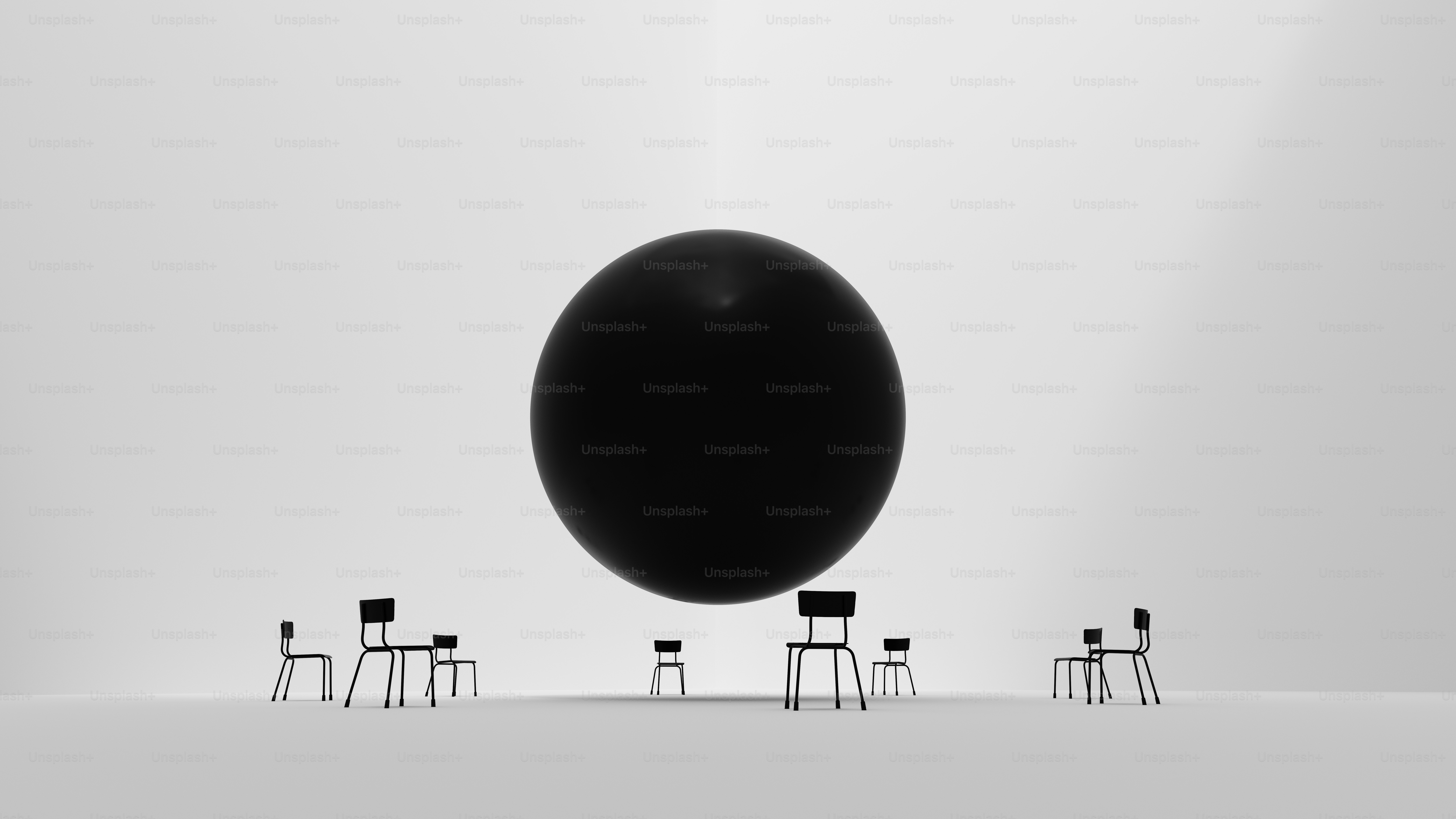 Um grupo de cadeiras sentando-se na frente de uma grande bola preta