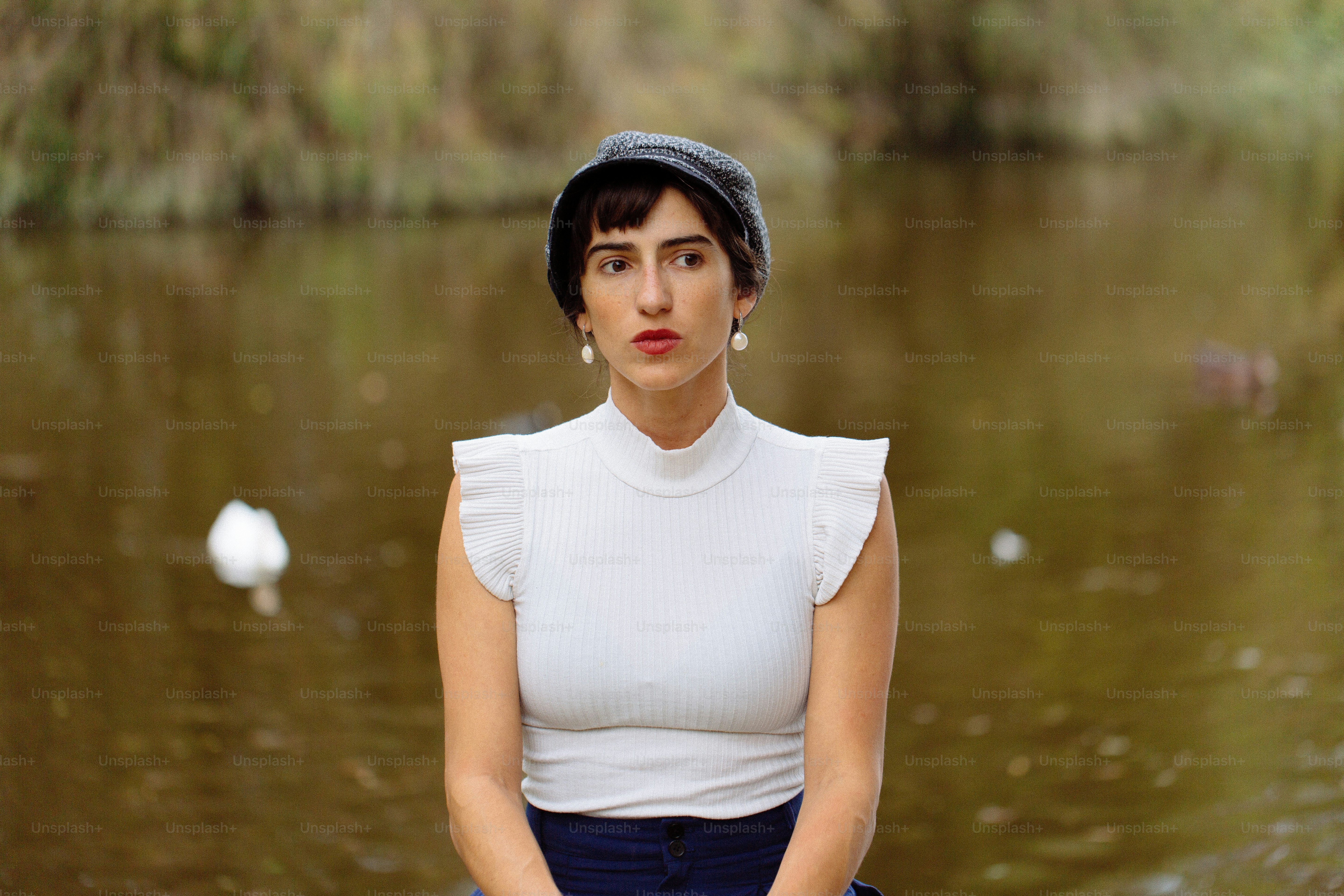 A woman sitting on a rock in front of a body of water