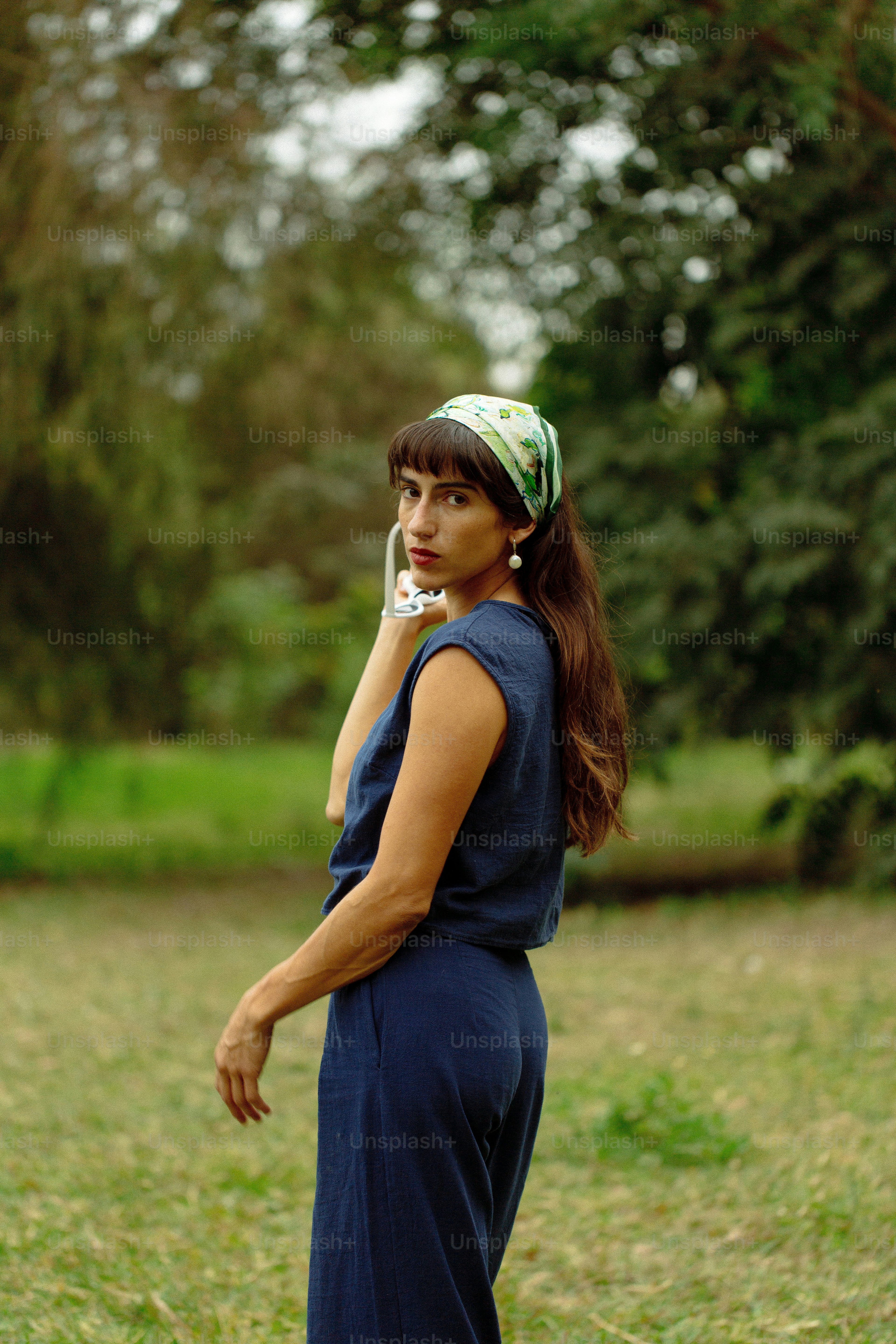 A woman standing in a field talking on a cell phone
