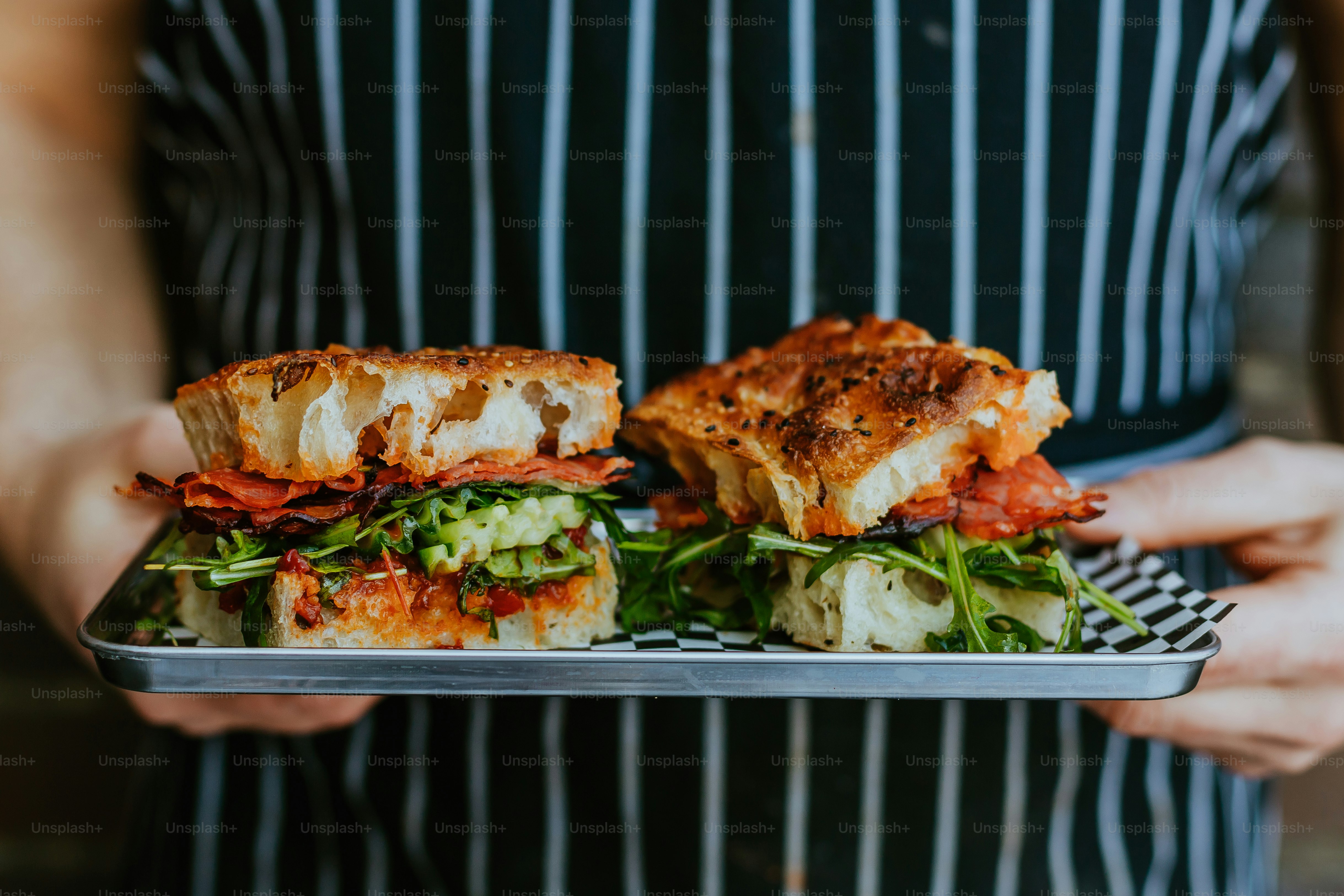 Una persona sosteniendo un plato con un sándwich