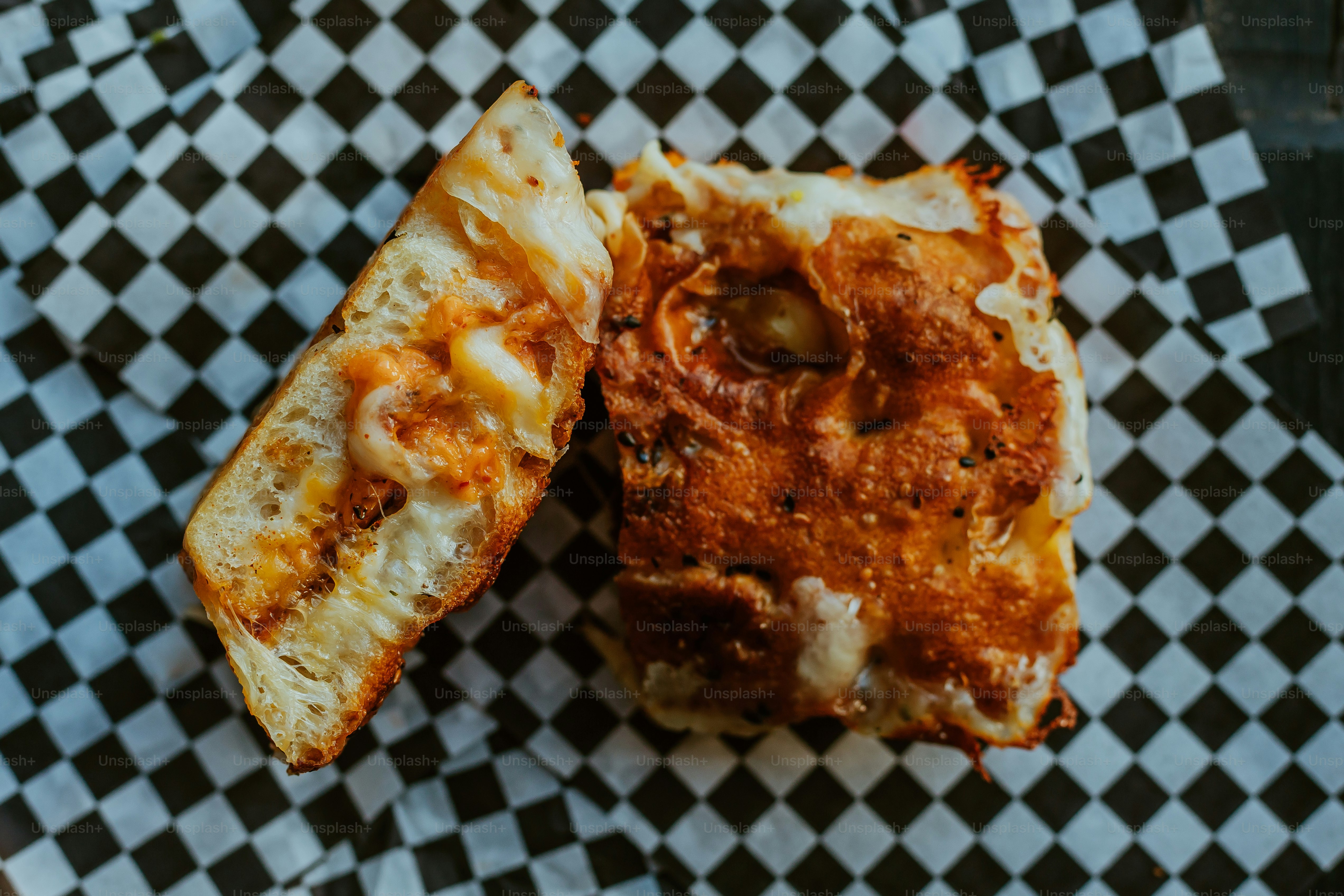 Two pieces of pizza sitting on top of a checkered paper