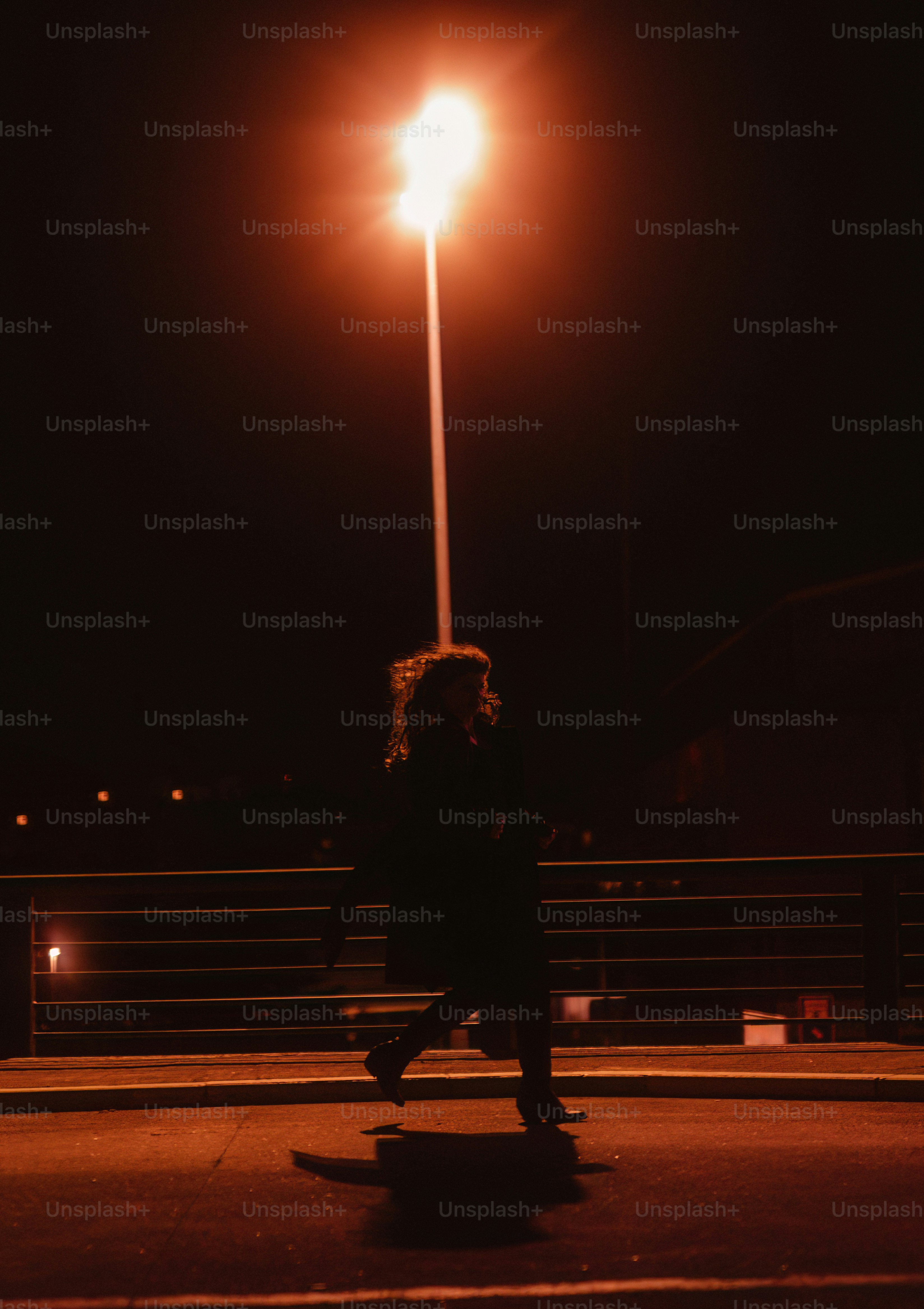 A woman walking down a street at night photo – City Image on Unsplash