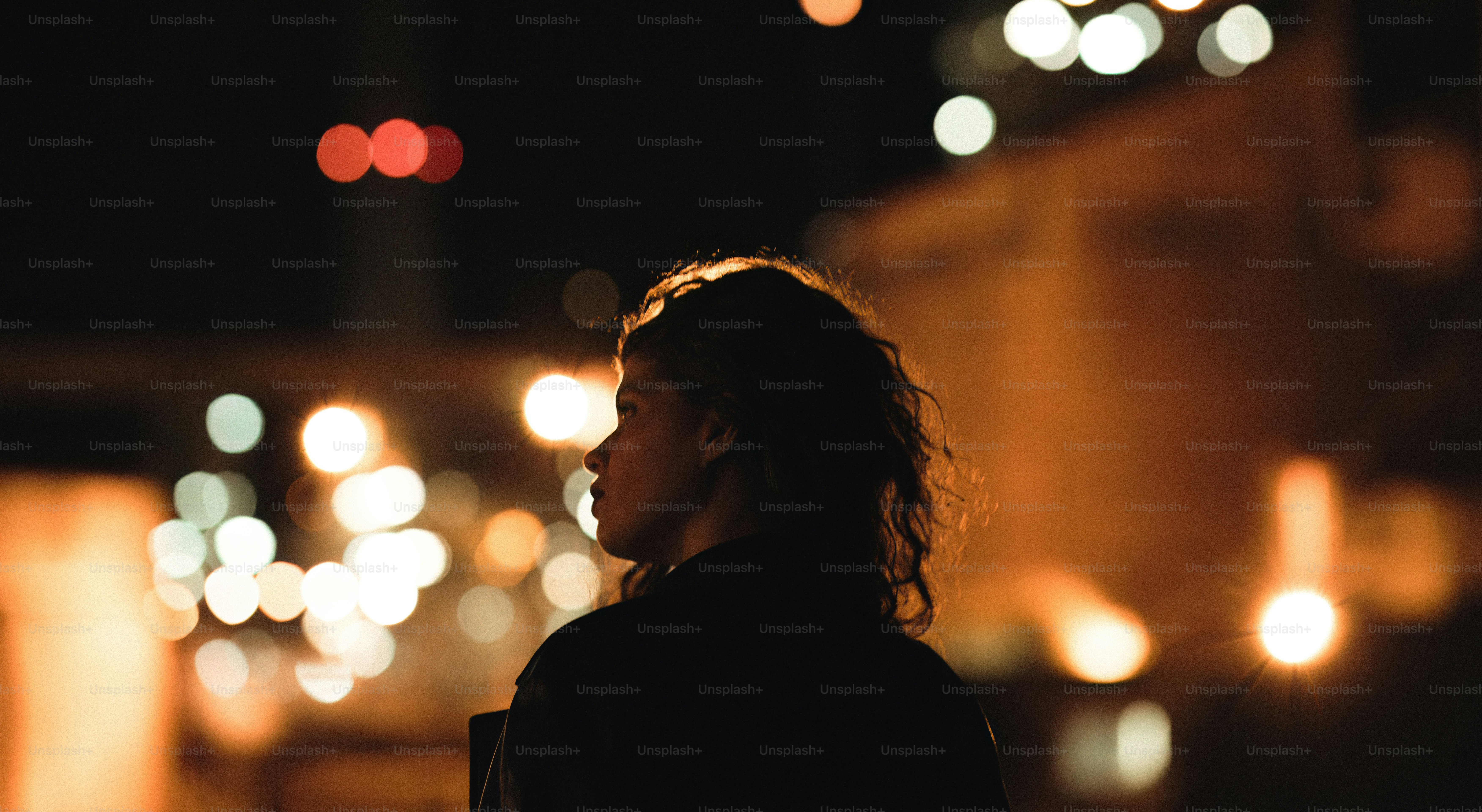 A person standing on a street at night photo – City Image on Unsplash