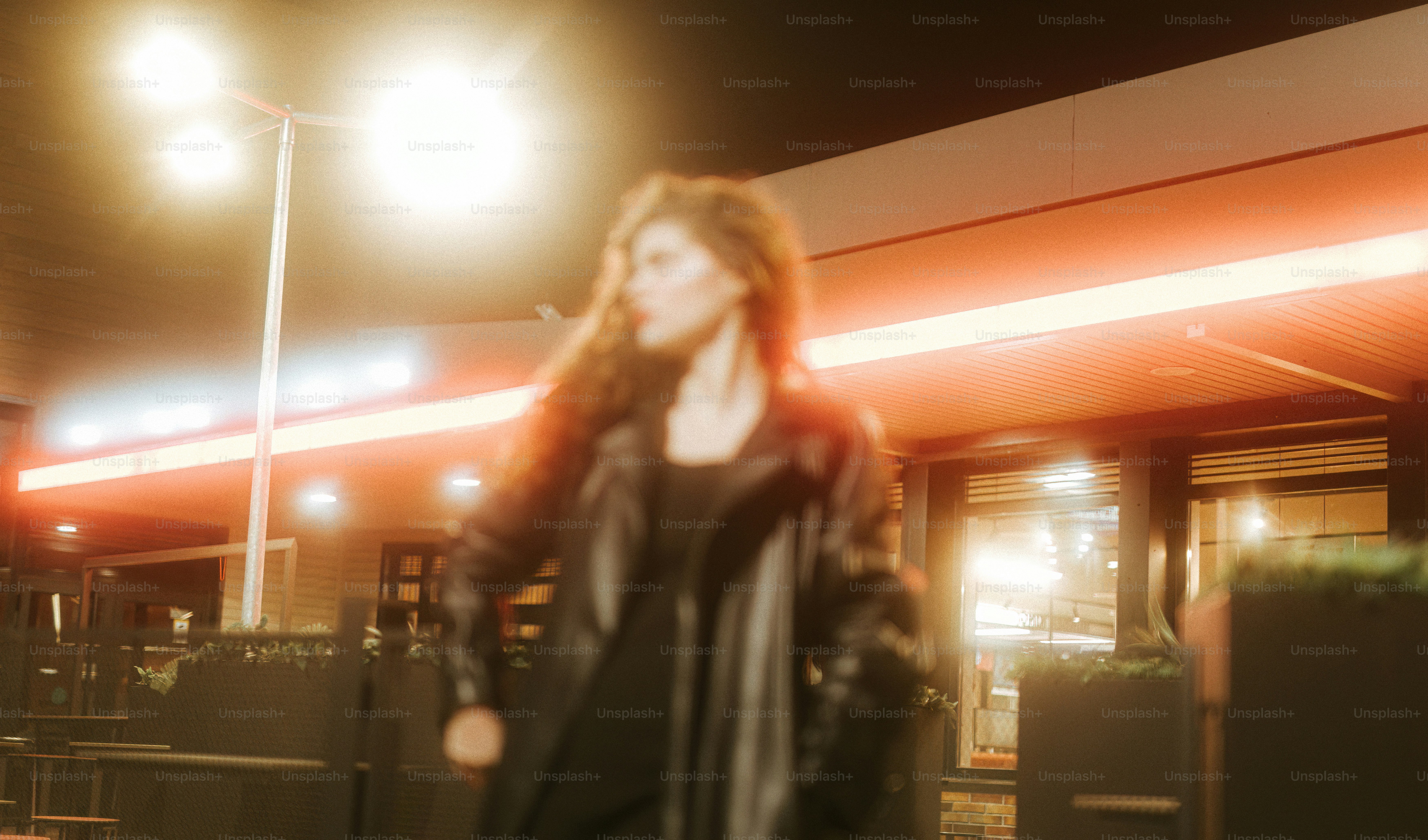 A woman walking down a street at night
