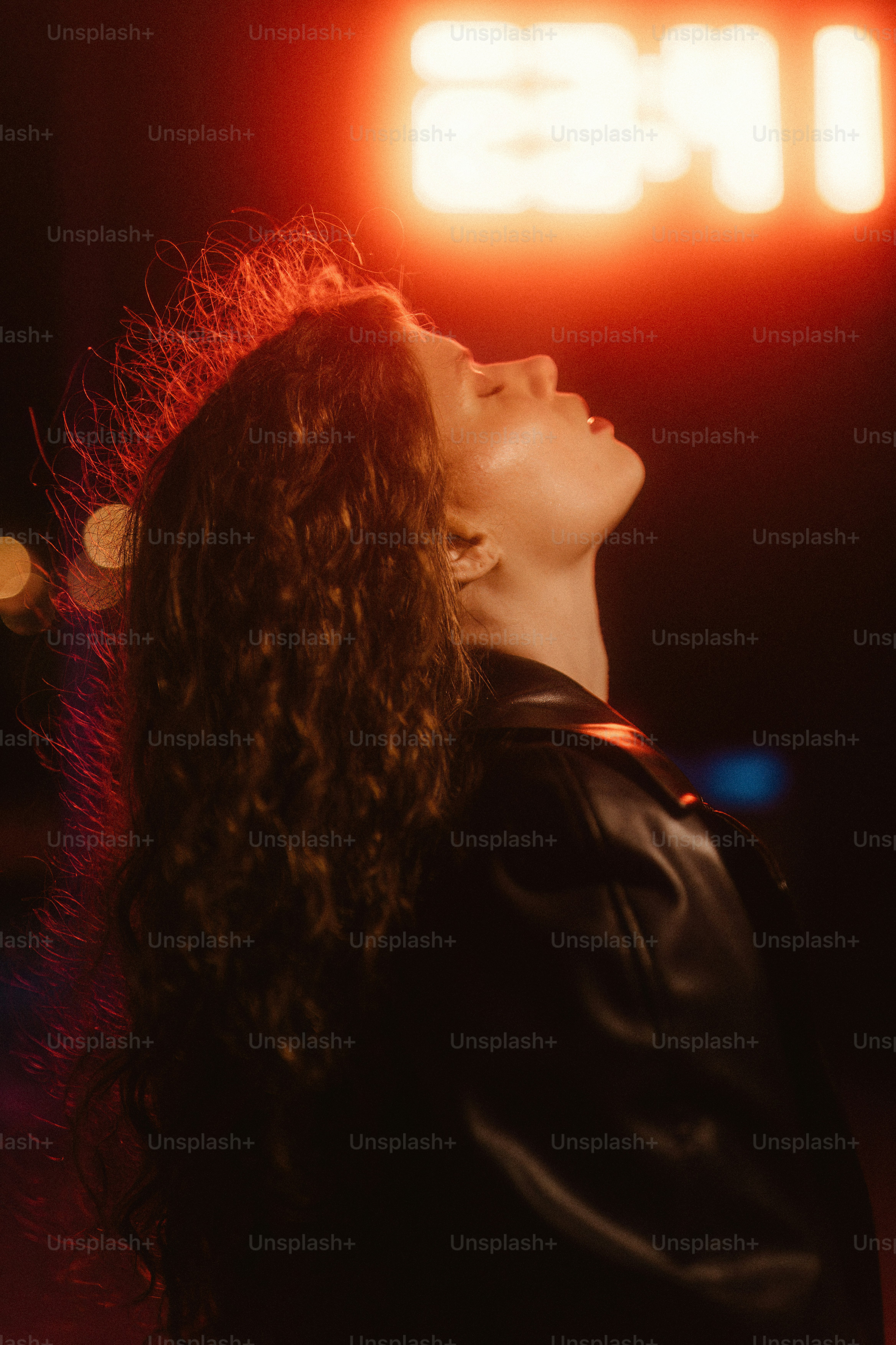 A woman standing in front of a neon sign photo – City Image on Unsplash