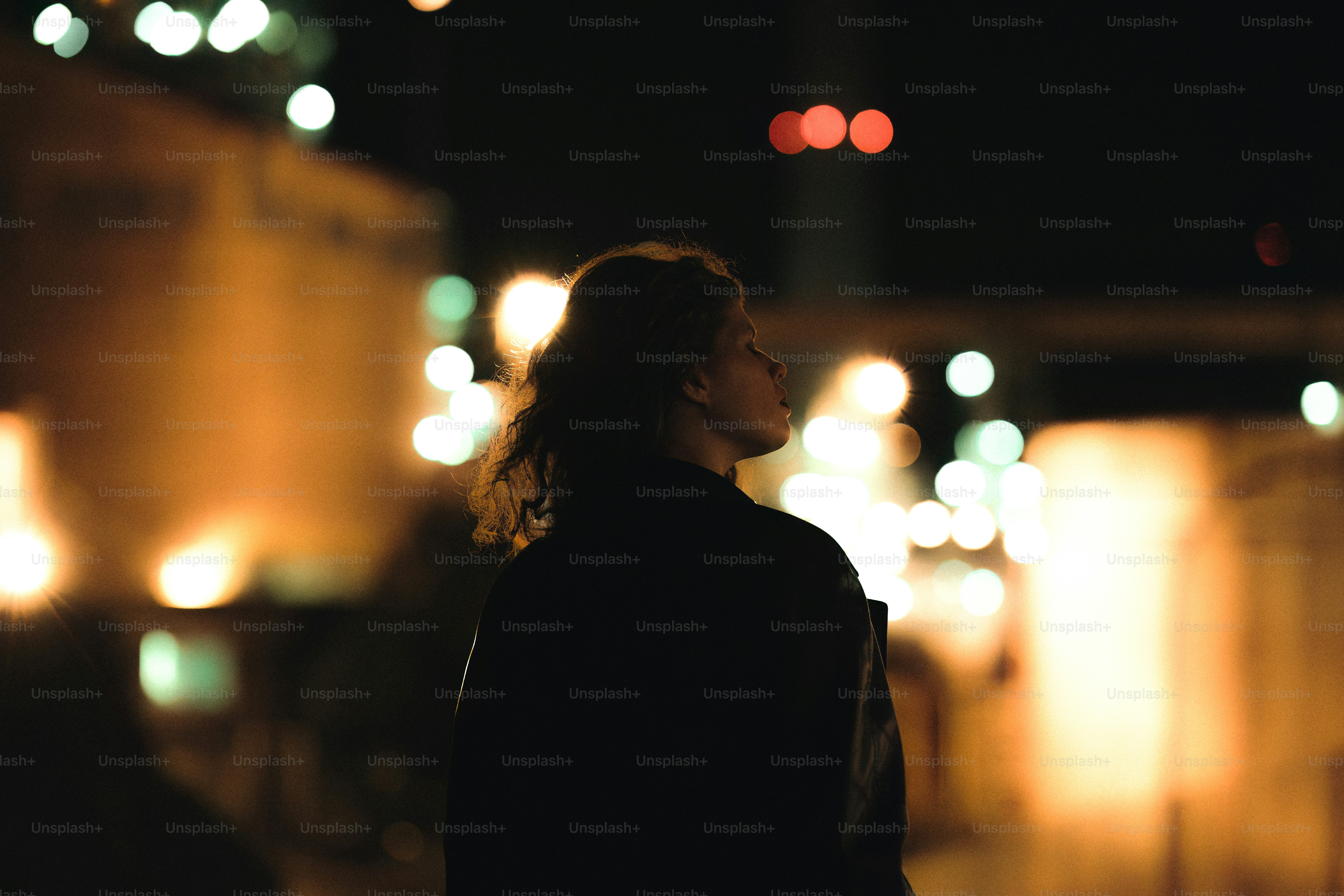 A woman standing on a street at night