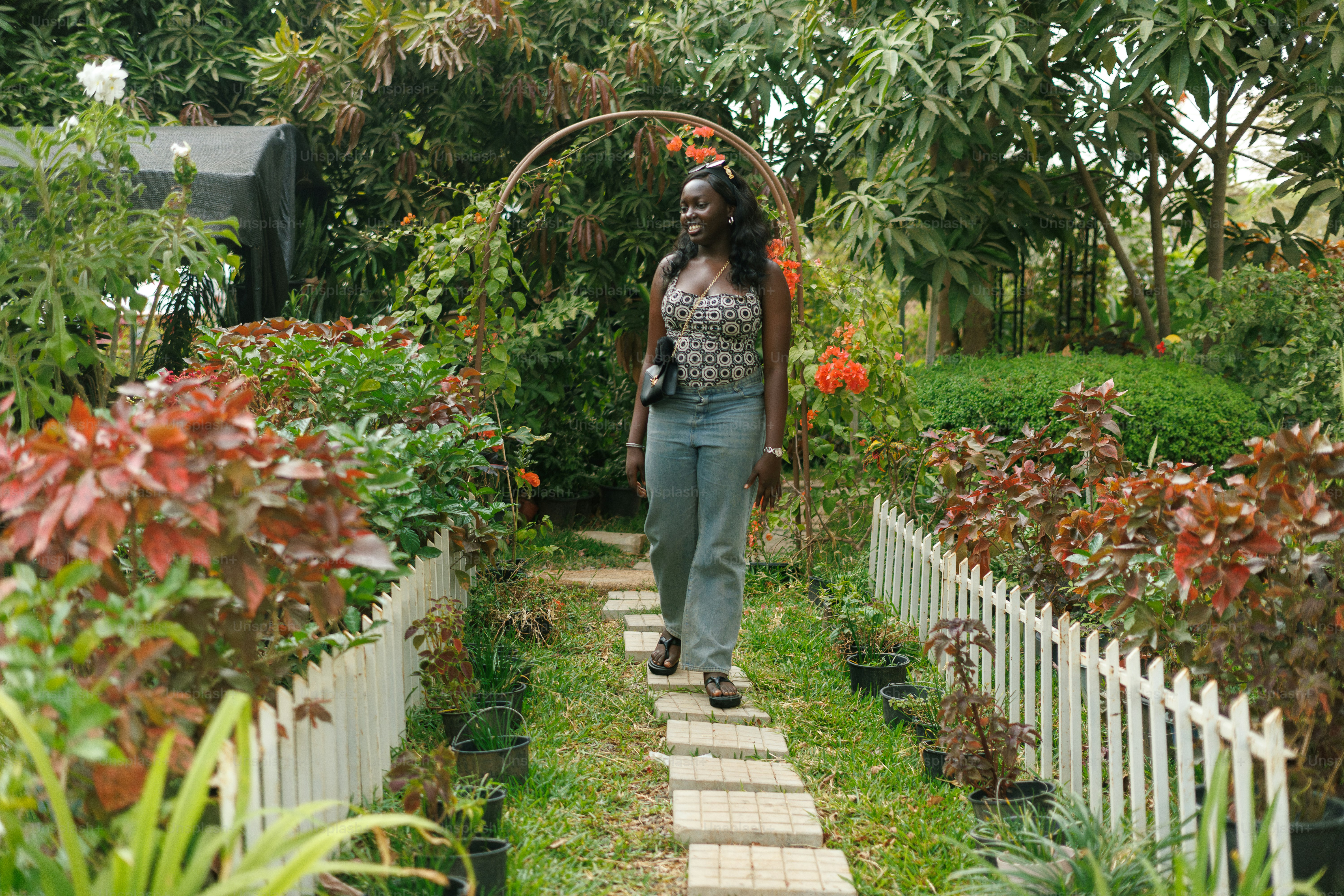 A woman walking down a path in a garden