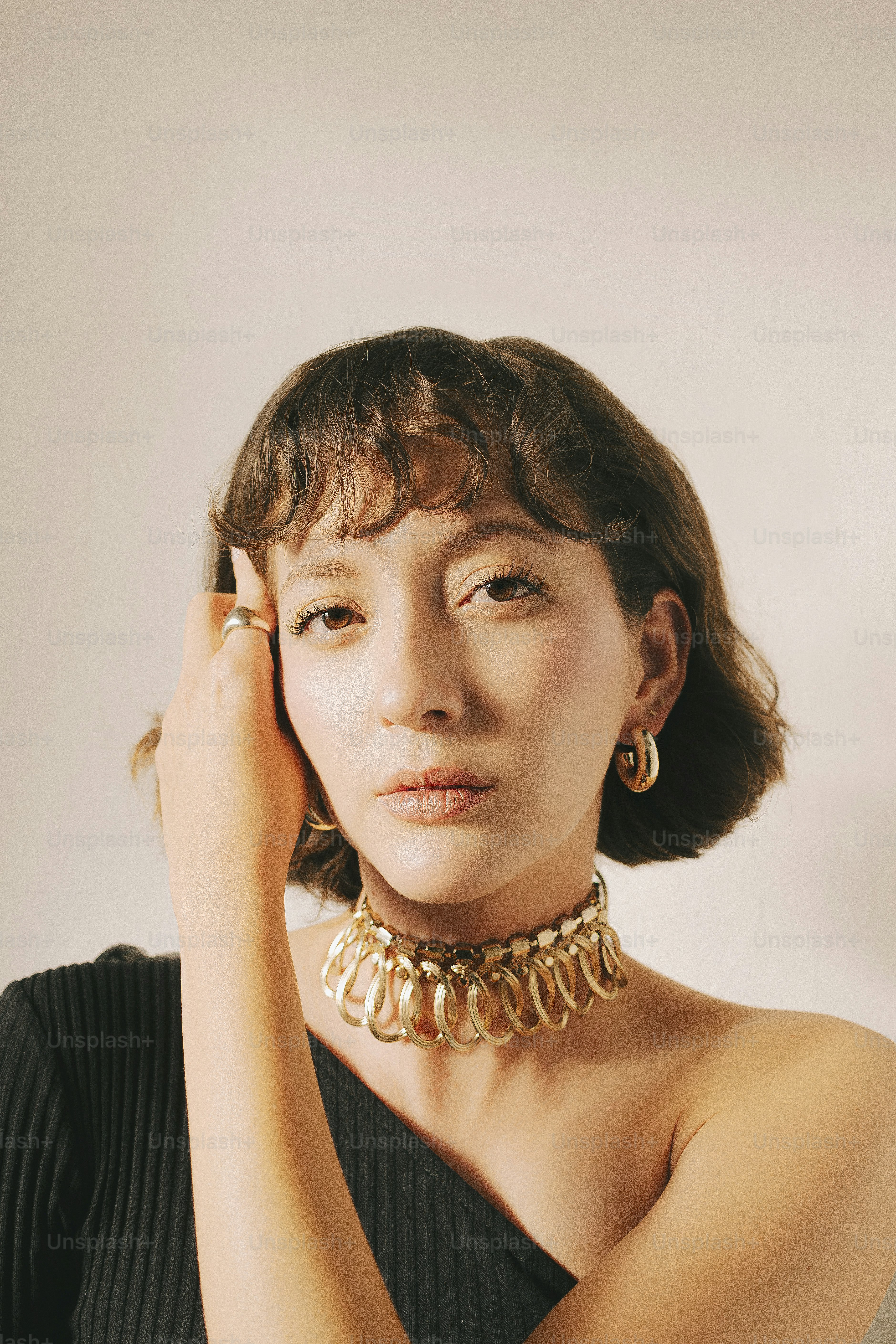 A woman in a black dress holding her hand to her face