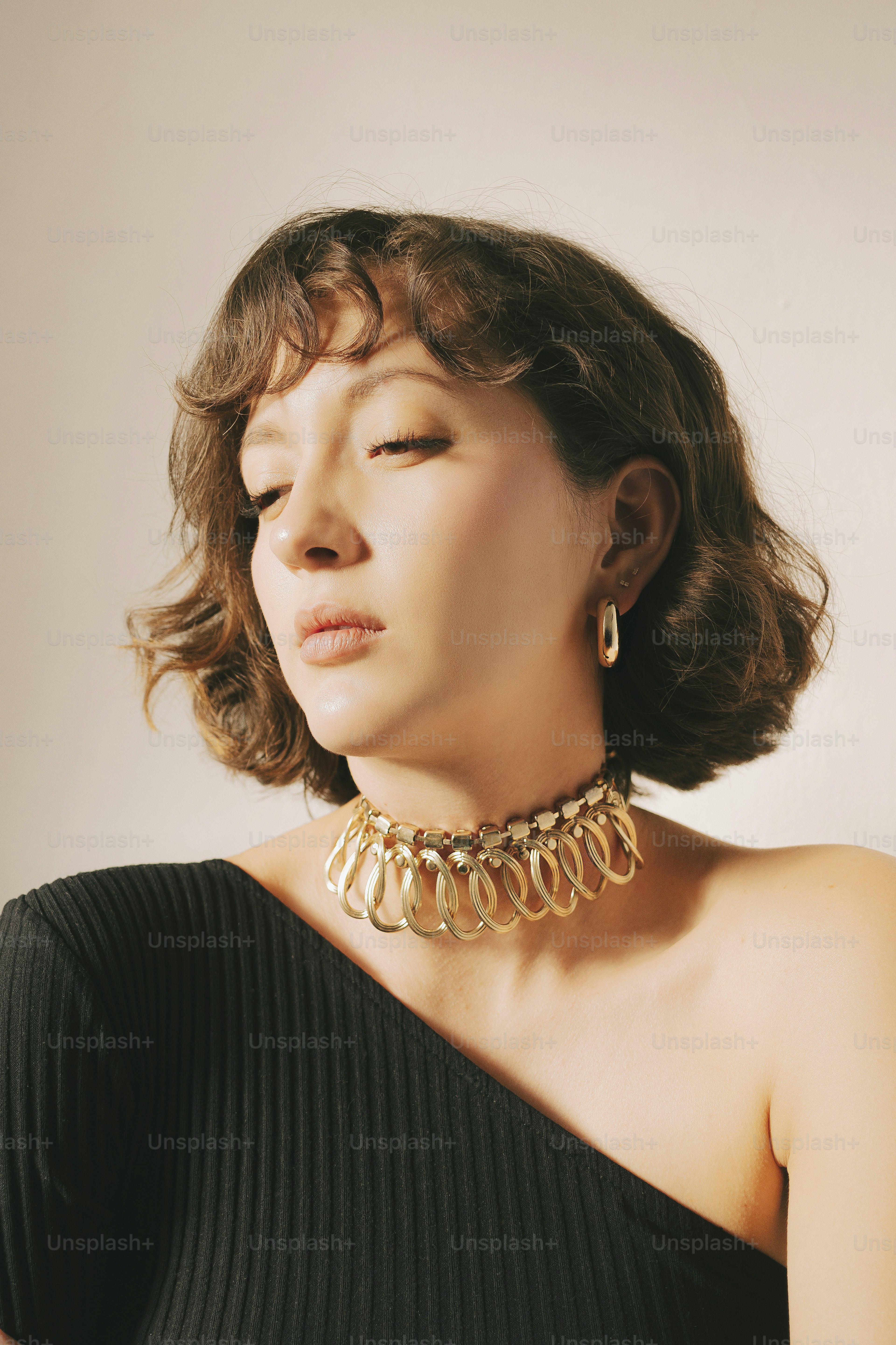 A woman wearing a black dress and a gold necklace