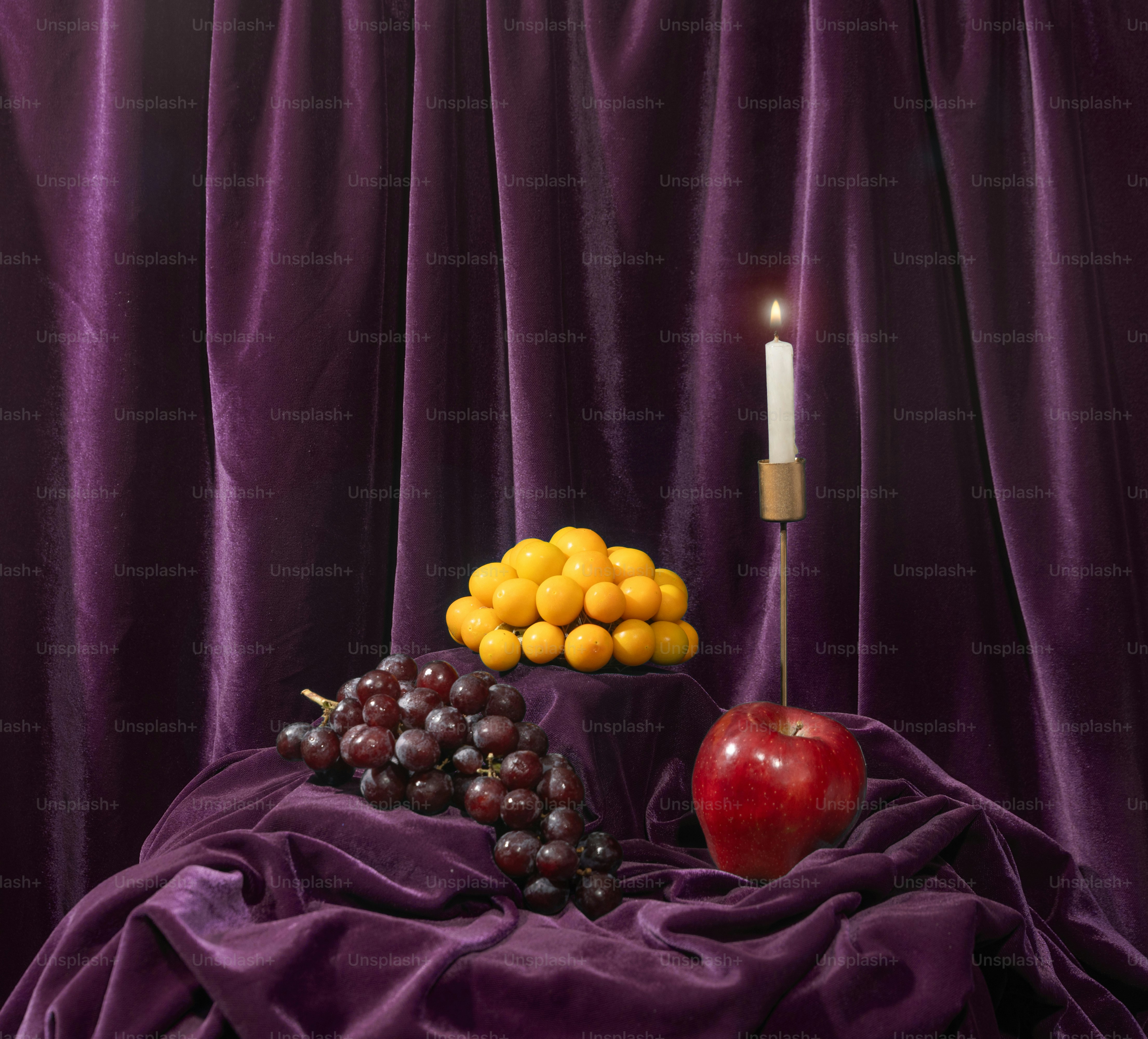 A table topped with fruit and a candle